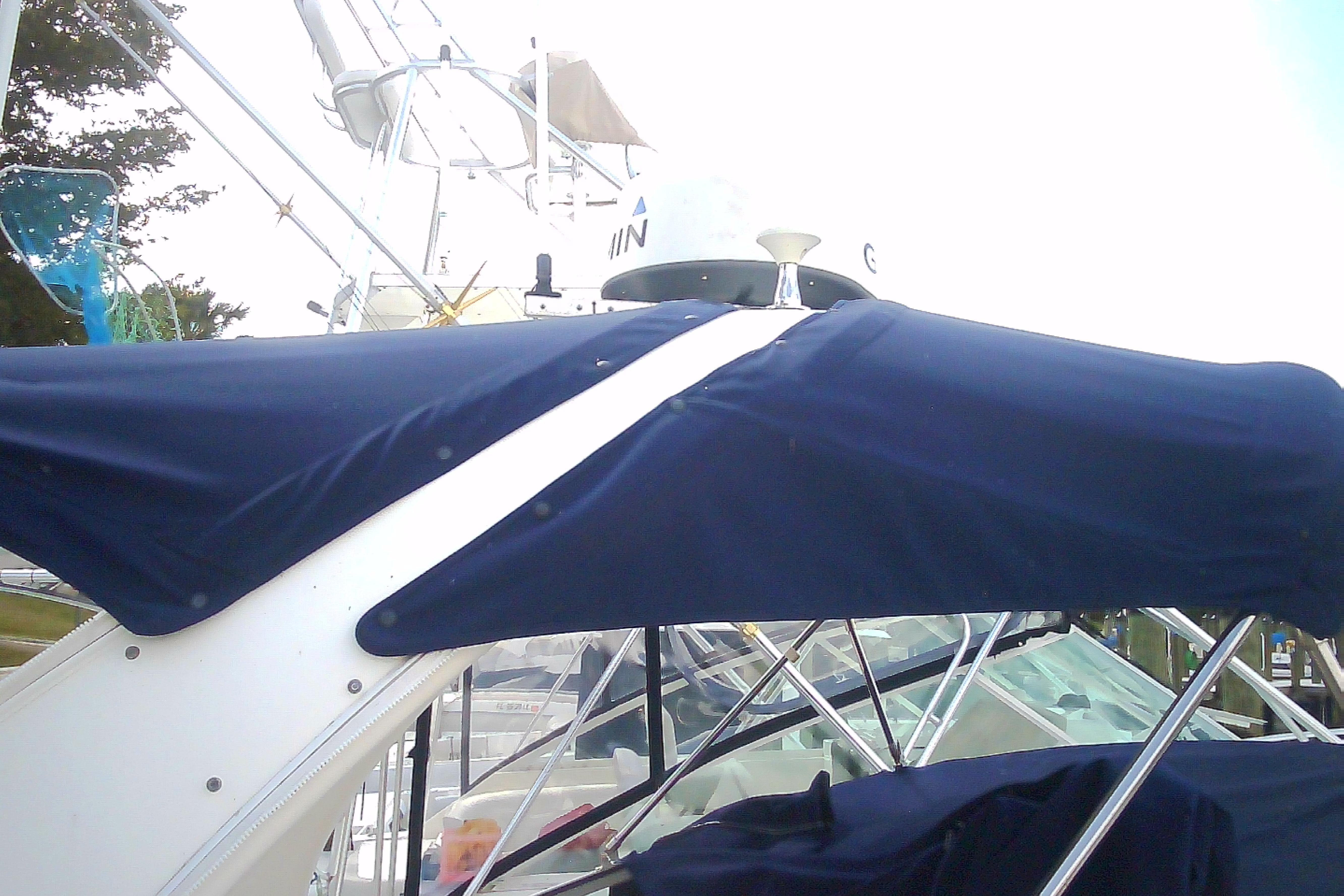 2005 Sea Ray 300 Sundancer with blue canvas cover and radar equipment.