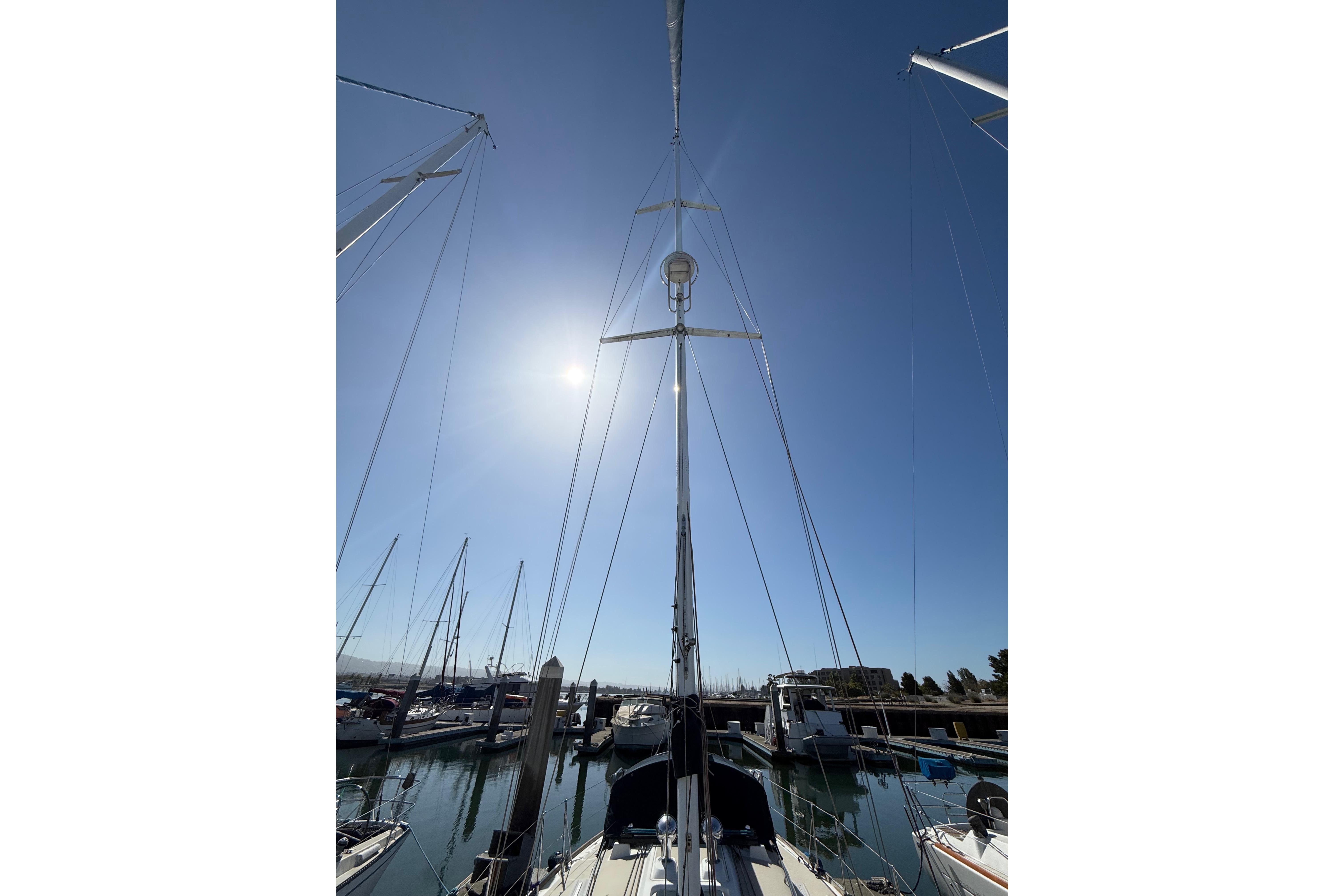 Sailboat mast of 2004 Sabre 386 in marina, under clear blue sky.