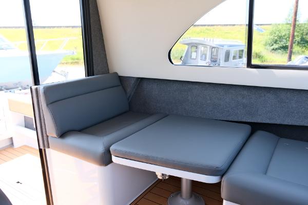 2023 Makaira Gen3 800 interior with gray seating and table, featuring modern design.