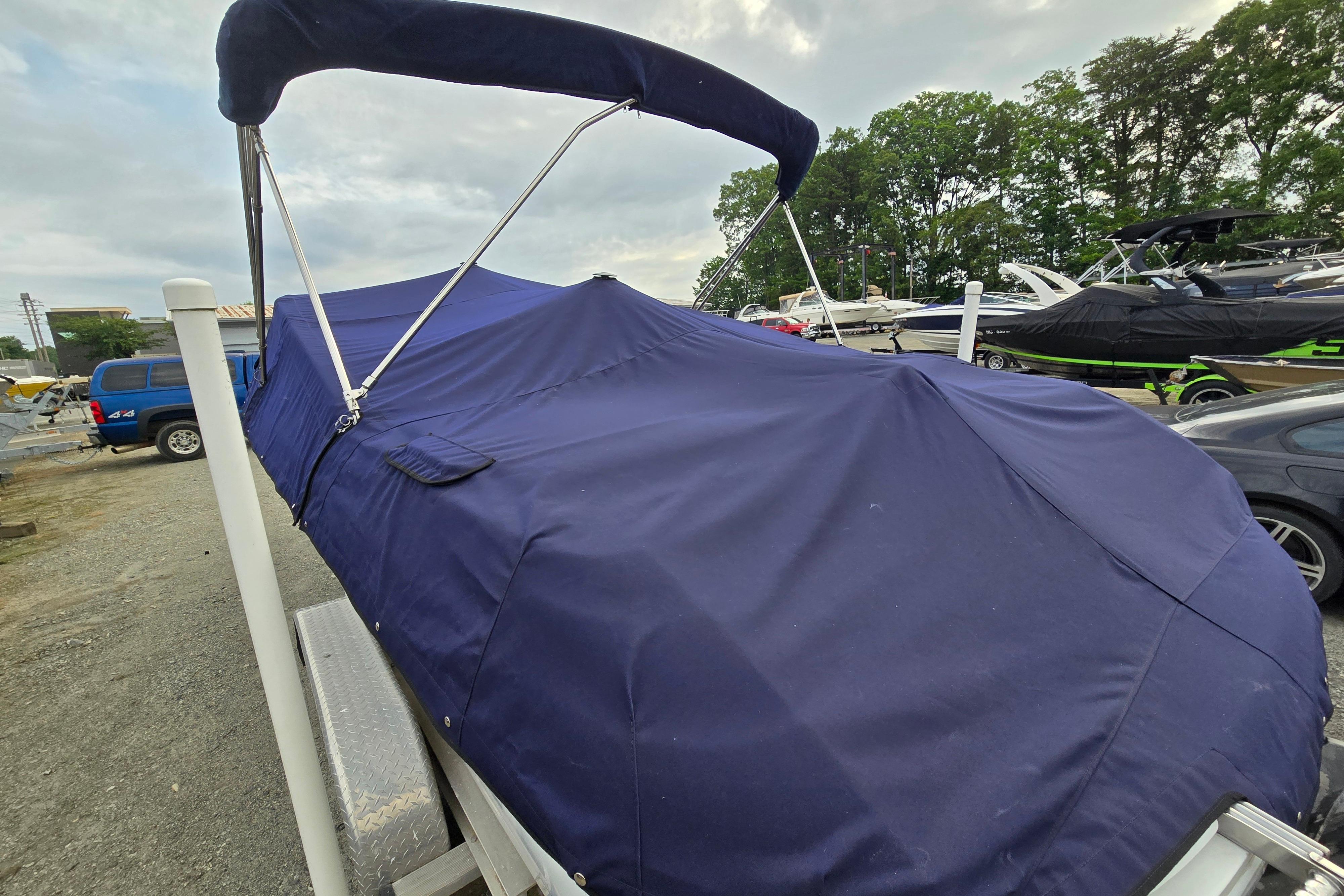 Covered 2000 Cobalt 246 boat on trailer, surrounded by other boats and vehicles.