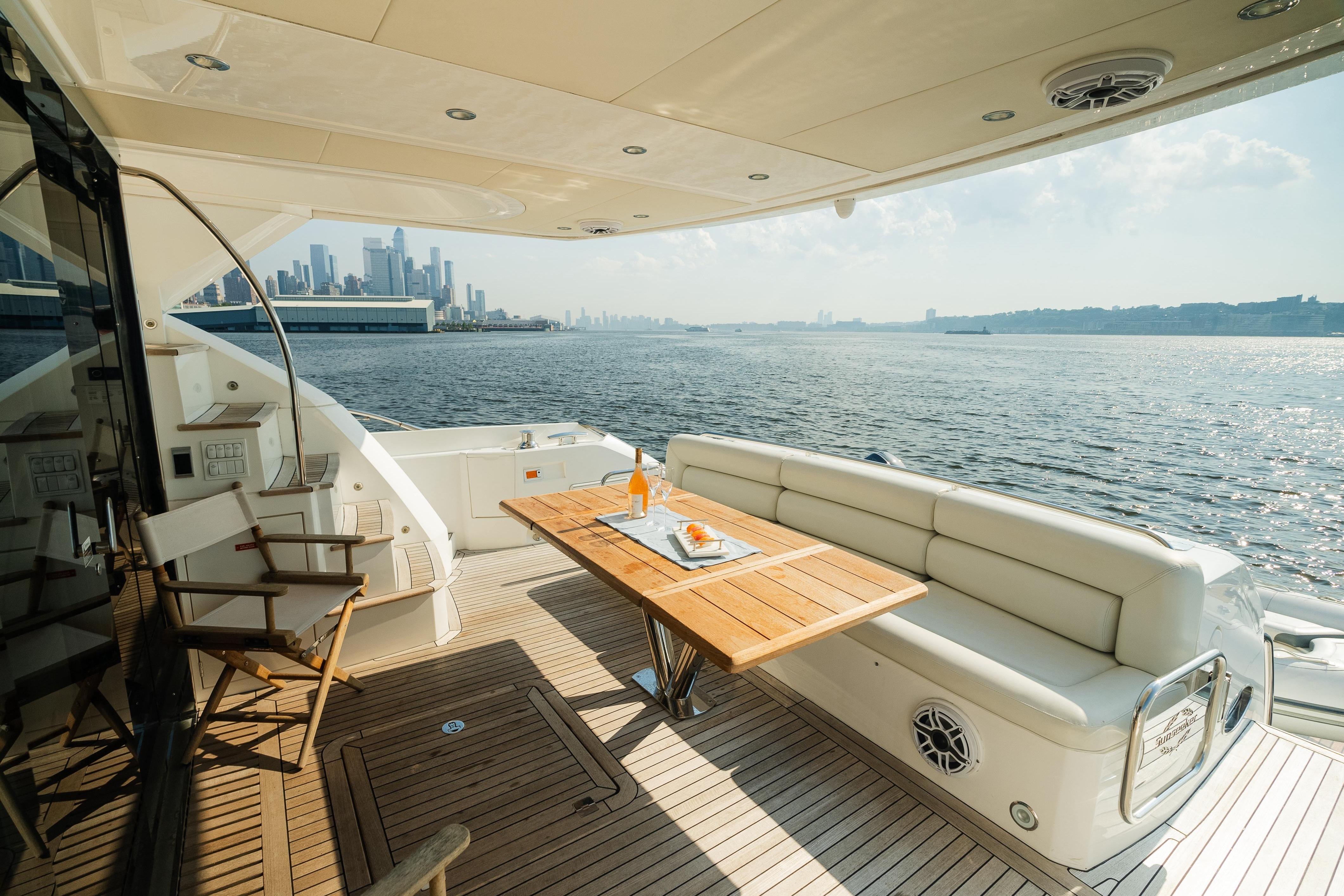 Luxurious 2016 Sunseeker Manhattan 65 yacht deck with city skyline view.