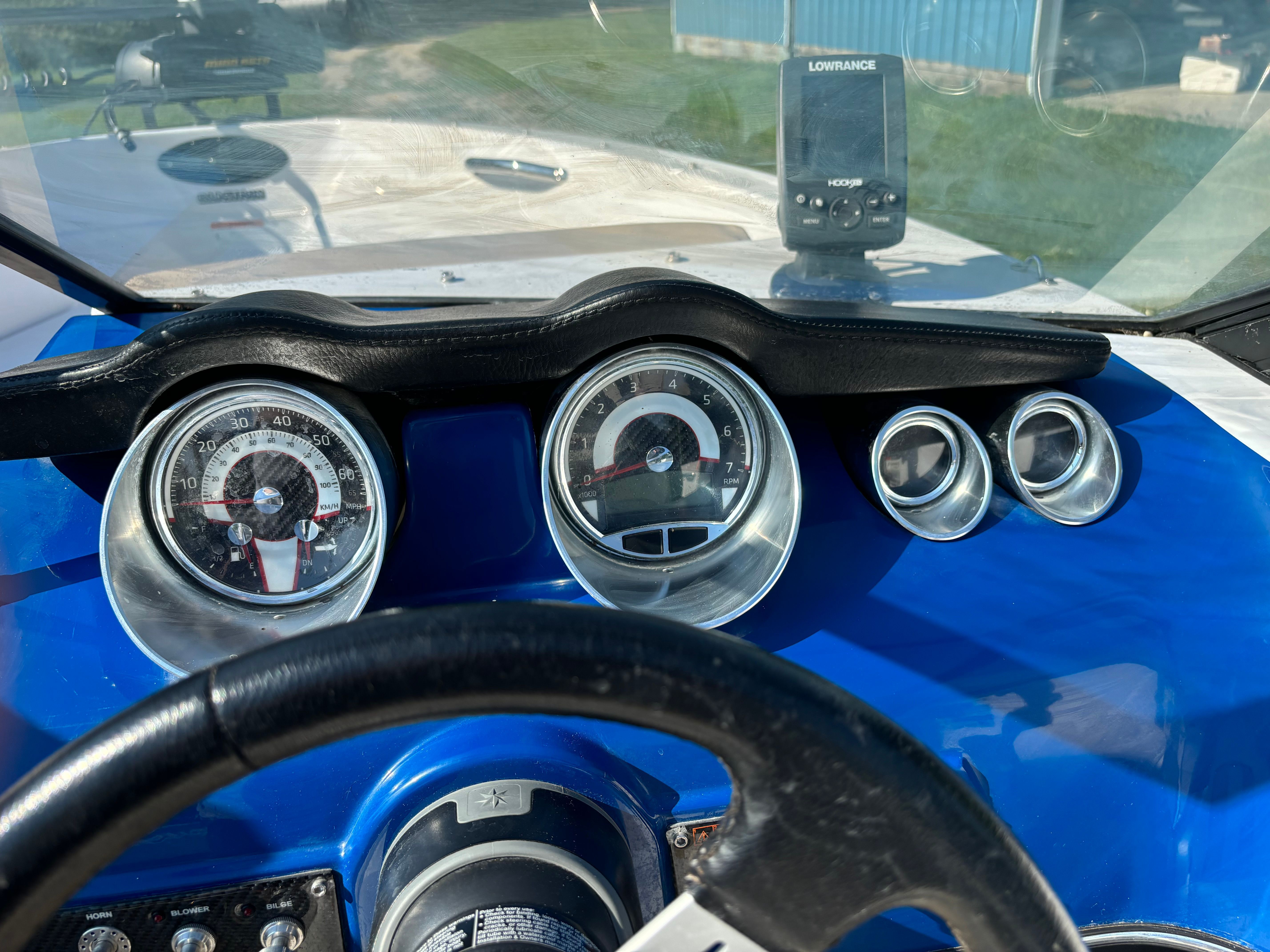 Close-up of a blue Glastron boat dashboard with speedometer and GPS.