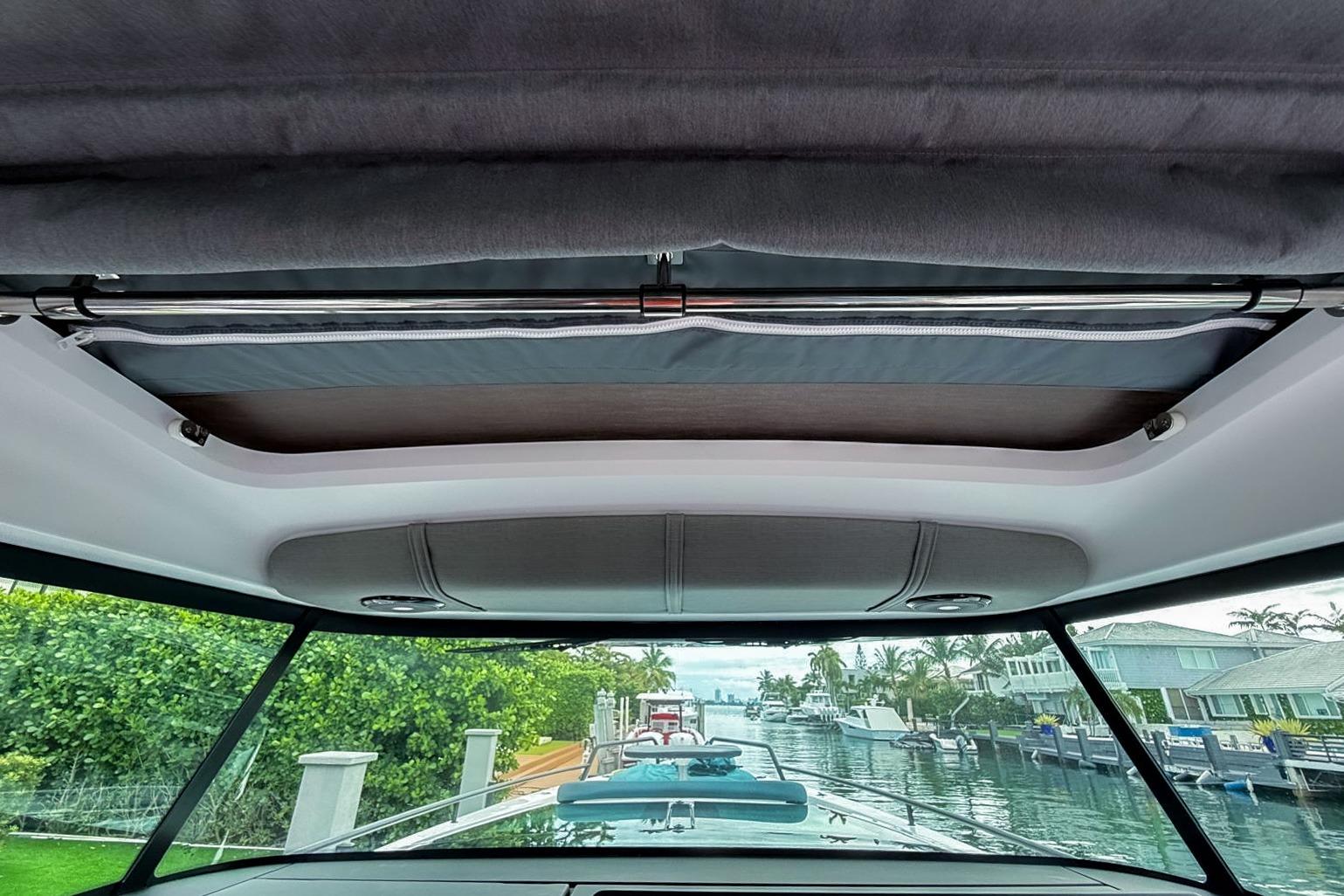 Interior view of 2023 Axopar 37 XC Cross Cabin, showcasing sunroof and canal scenery.