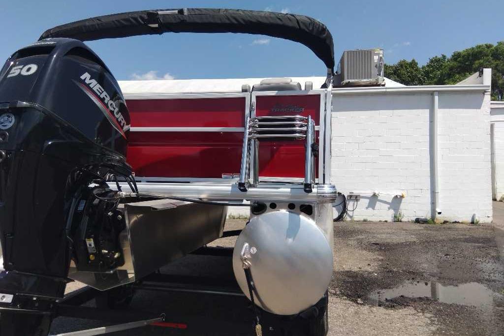 2026 Sun Tracker Party Barge 16 DLX with Mercury engine, parked outdoors.