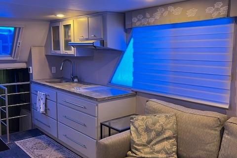 Modern kitchen interior in a 1977 Gibson Standard boat with blue lighting.