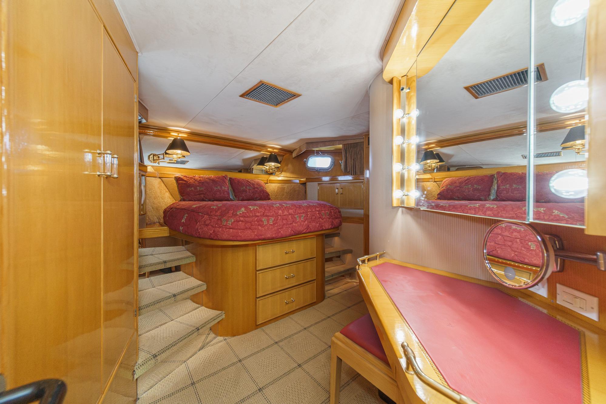 Luxurious 1990 Seaton Long Range Cruiser cabin with elegant wood finishes and cozy bedding.