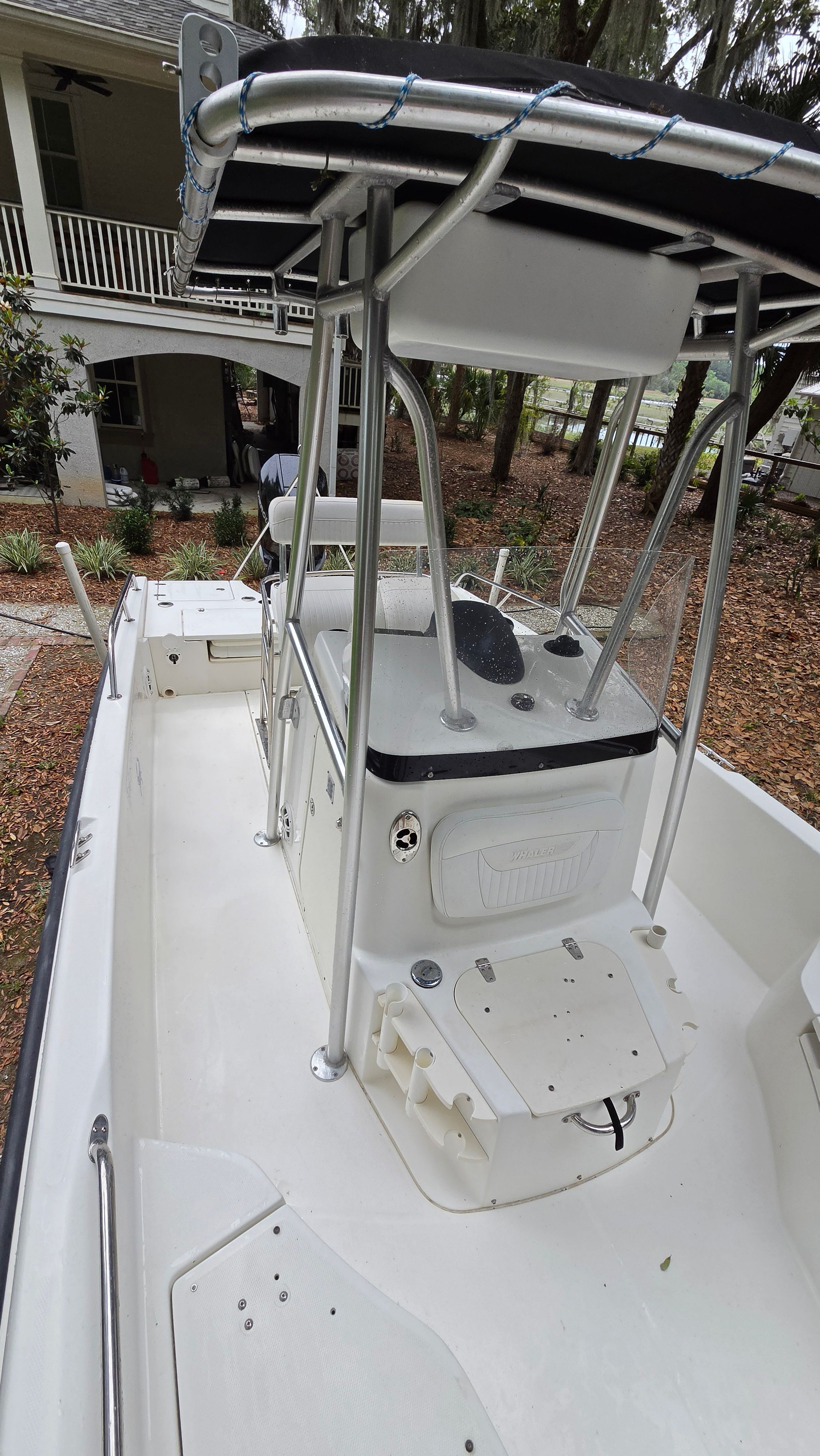 The image shows a 2008 Boston Whaler 230 Dauntless boat with a central console and T-top.