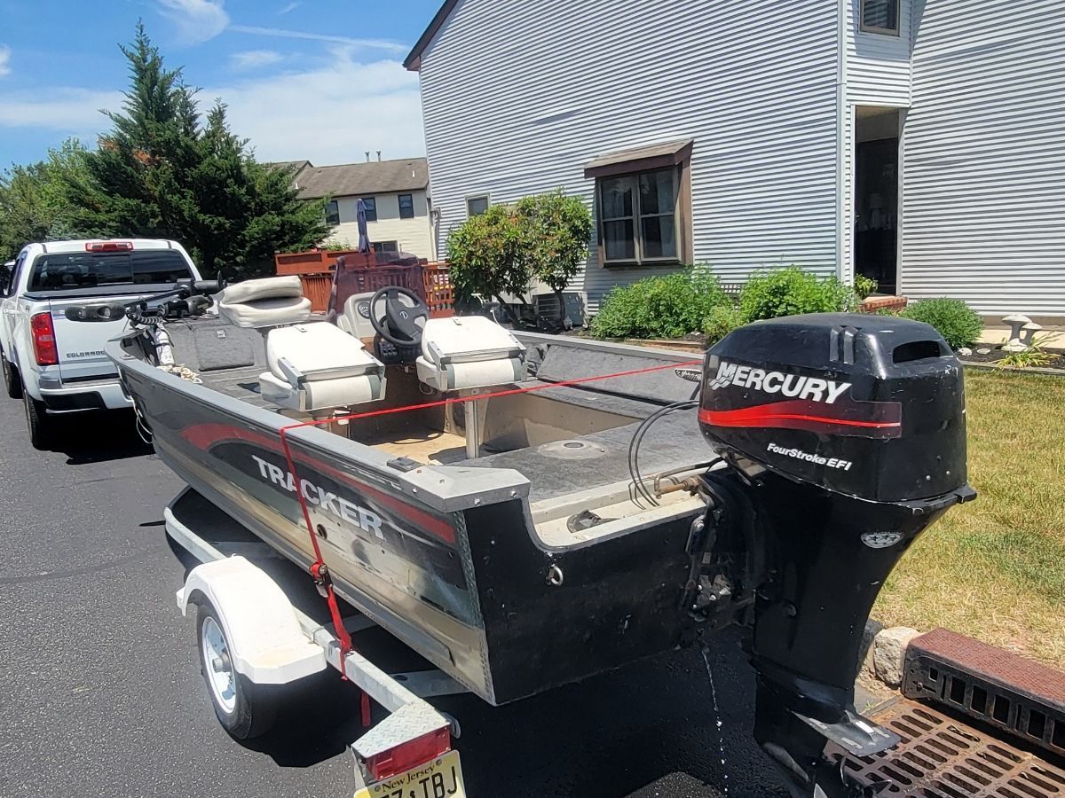 A 1997 Tracker Super Guide V16 on a trailer, featuring a Mercury outboard motor.
