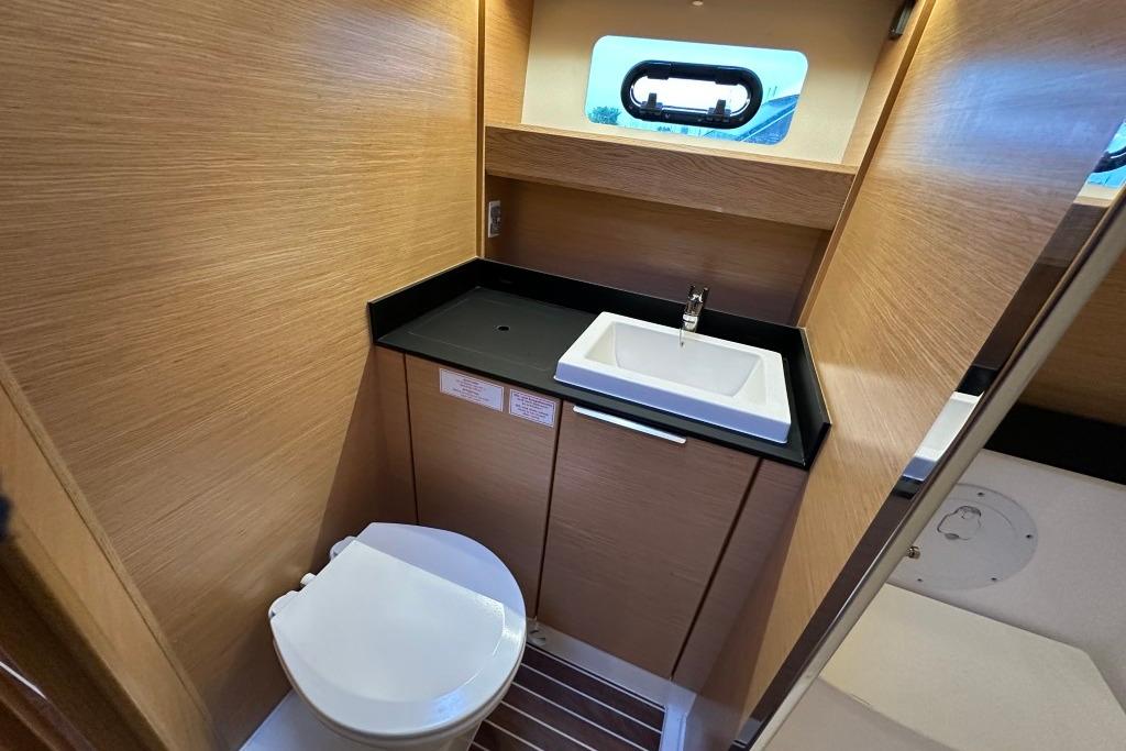 Modern bathroom interior of 2017 Bavaria S40 HT yacht with sink and toilet.