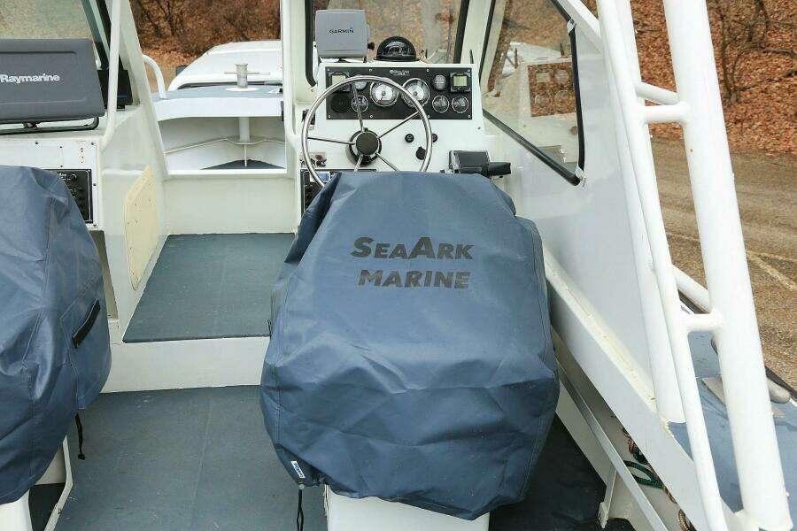 2002 SeaArk 25 V Commander SAMA 1365 boat interior with covered seats and steering wheel.
