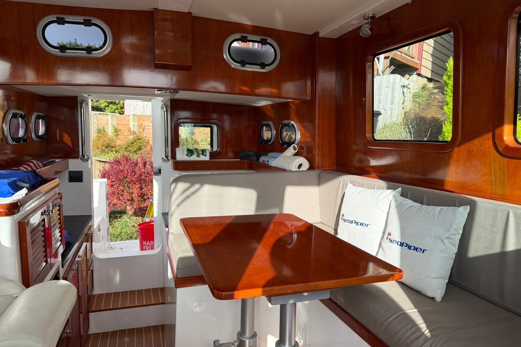 Interior of 2020 SeaPiper 35 boat with wooden finishes and cozy seating area.