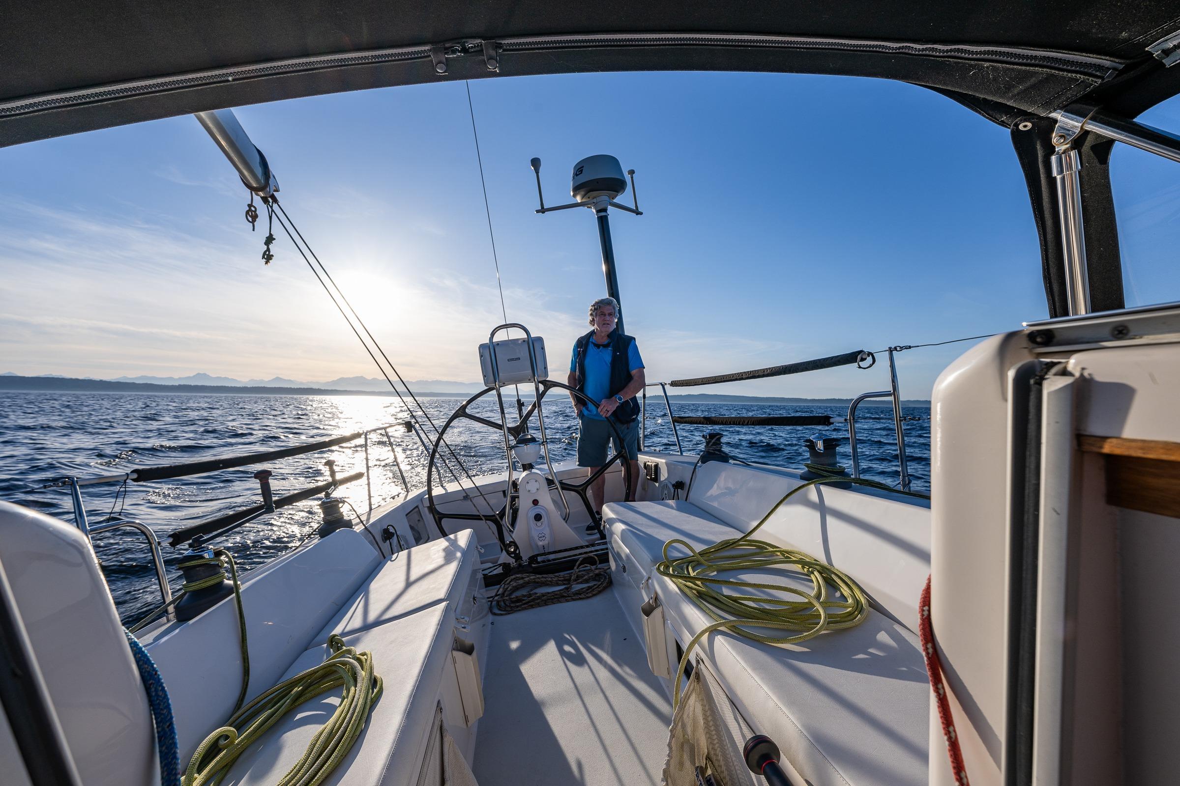 Sailing on a 2007 J Boats J/124 yacht at sunset, with a person at the helm.