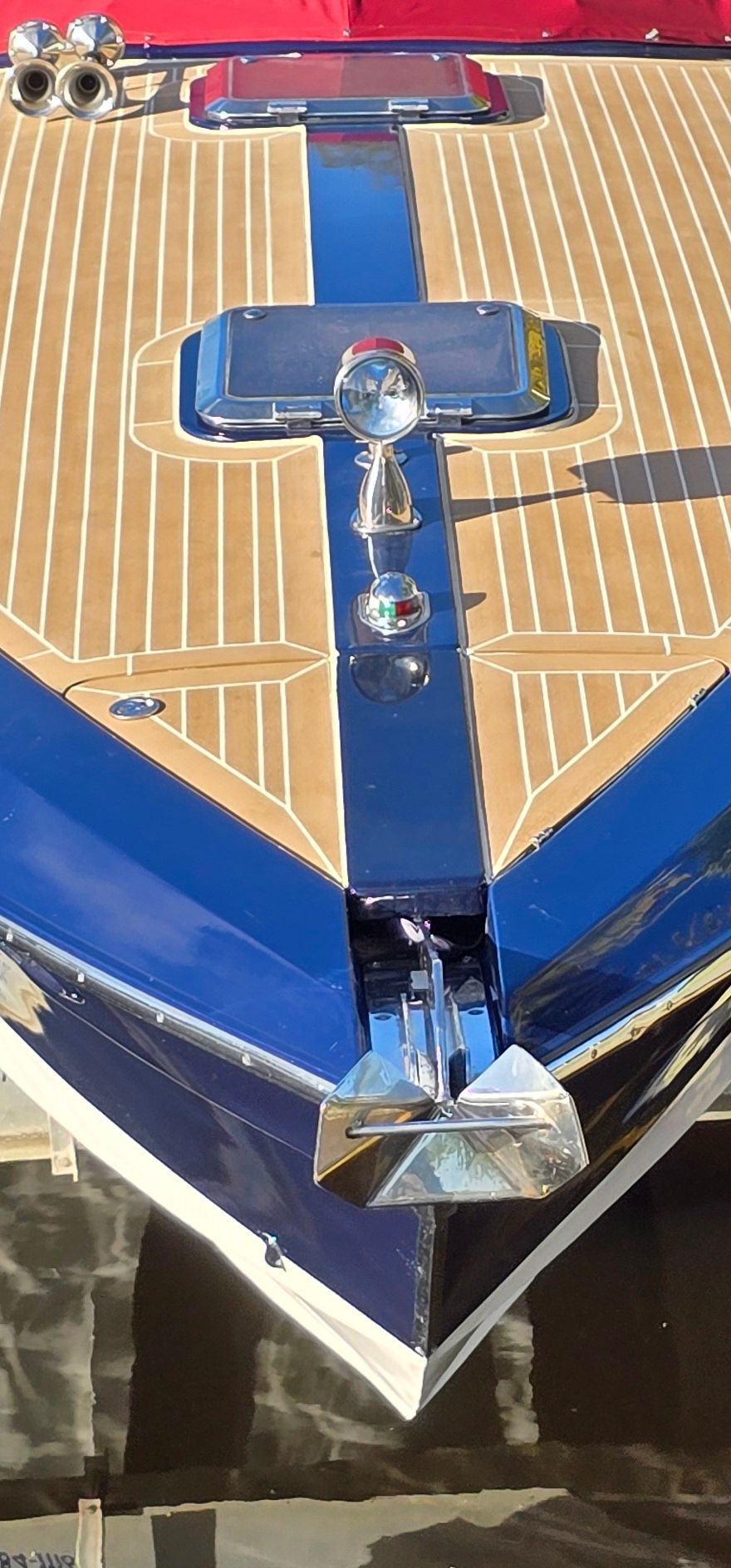 The bow of a 2002 Cruisers Cabriolet Royale 34 with a blue and wood-toned deck.
