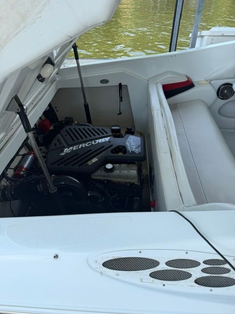 A 2002 Baja 25 Outlaw with an open engine compartment revealing a Mercury engine.