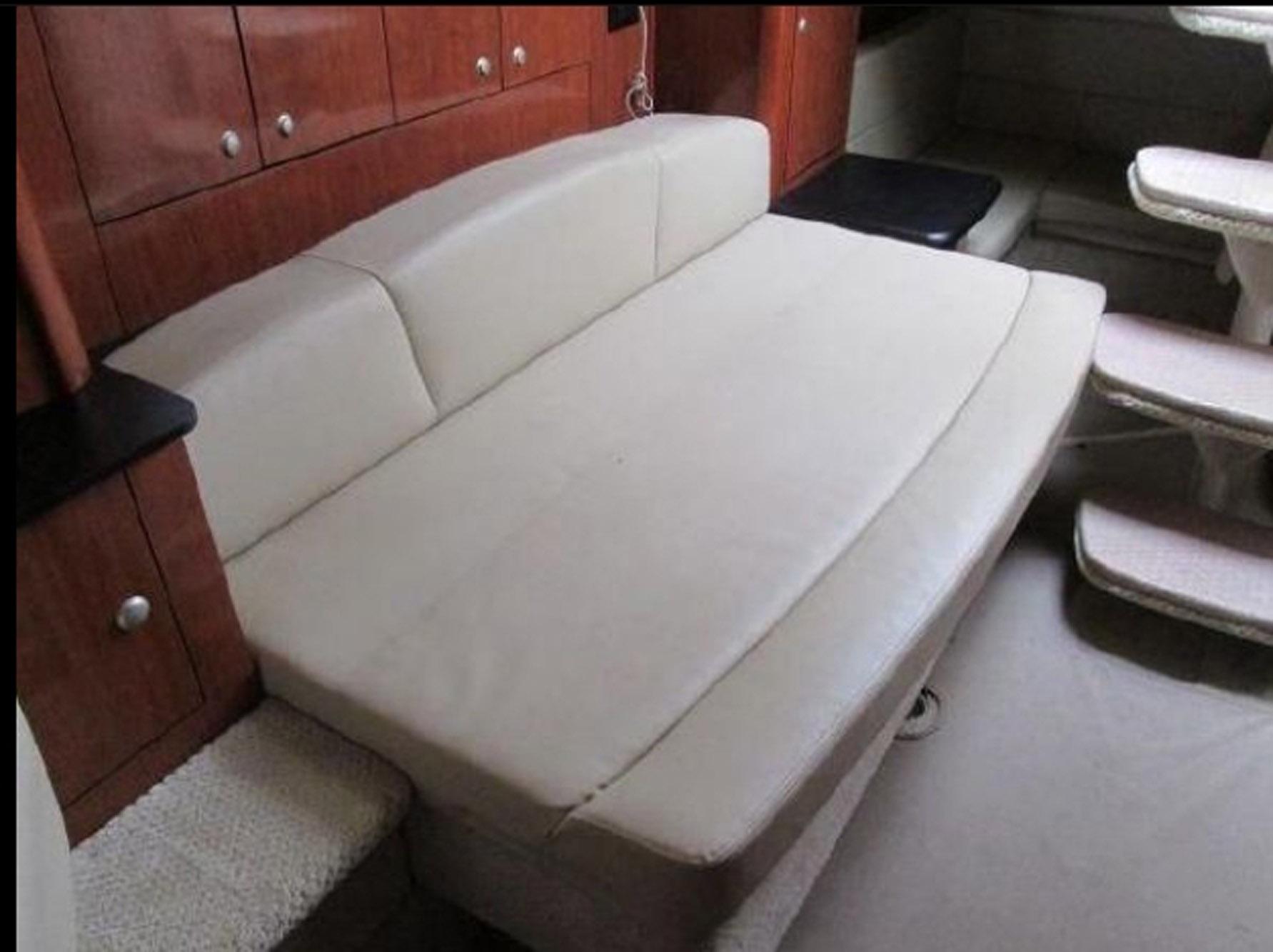 2007 Sea Ray 310 Sundancer interior with beige seating and wooden cabinetry.