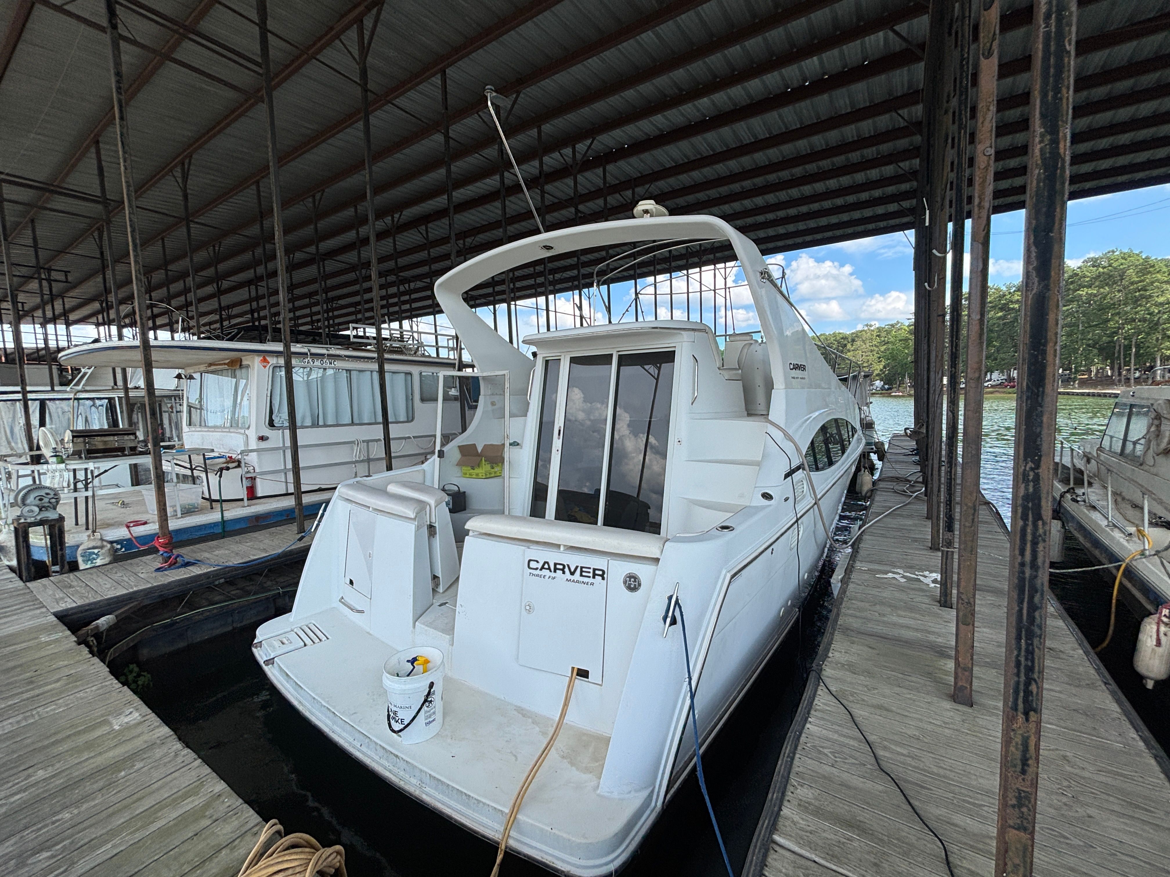A 2001 Carver 350 Mariner is docked under a covered area.