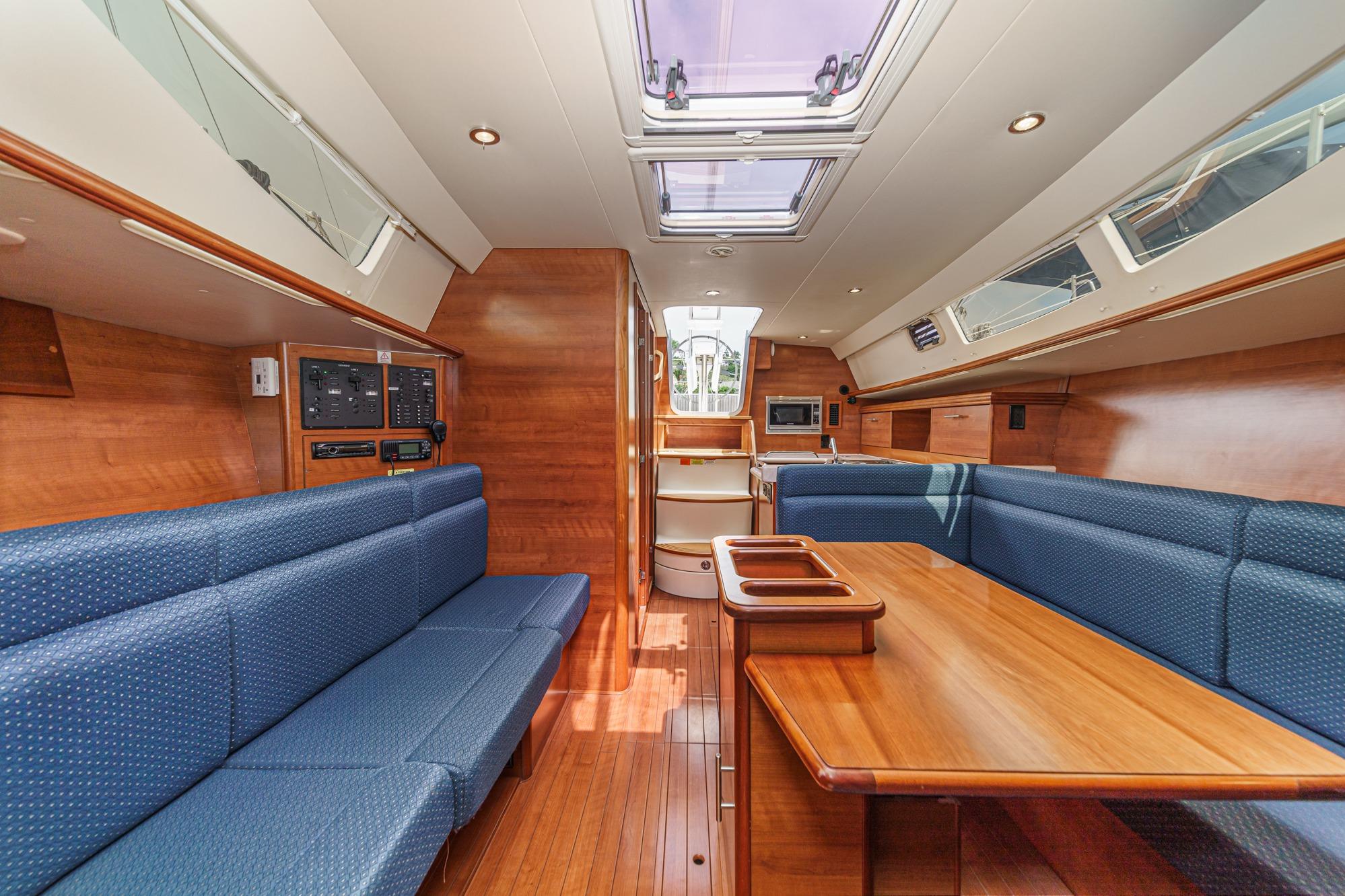 Interior of 2015 Hunter 33 sailboat with wood finish and blue seating.