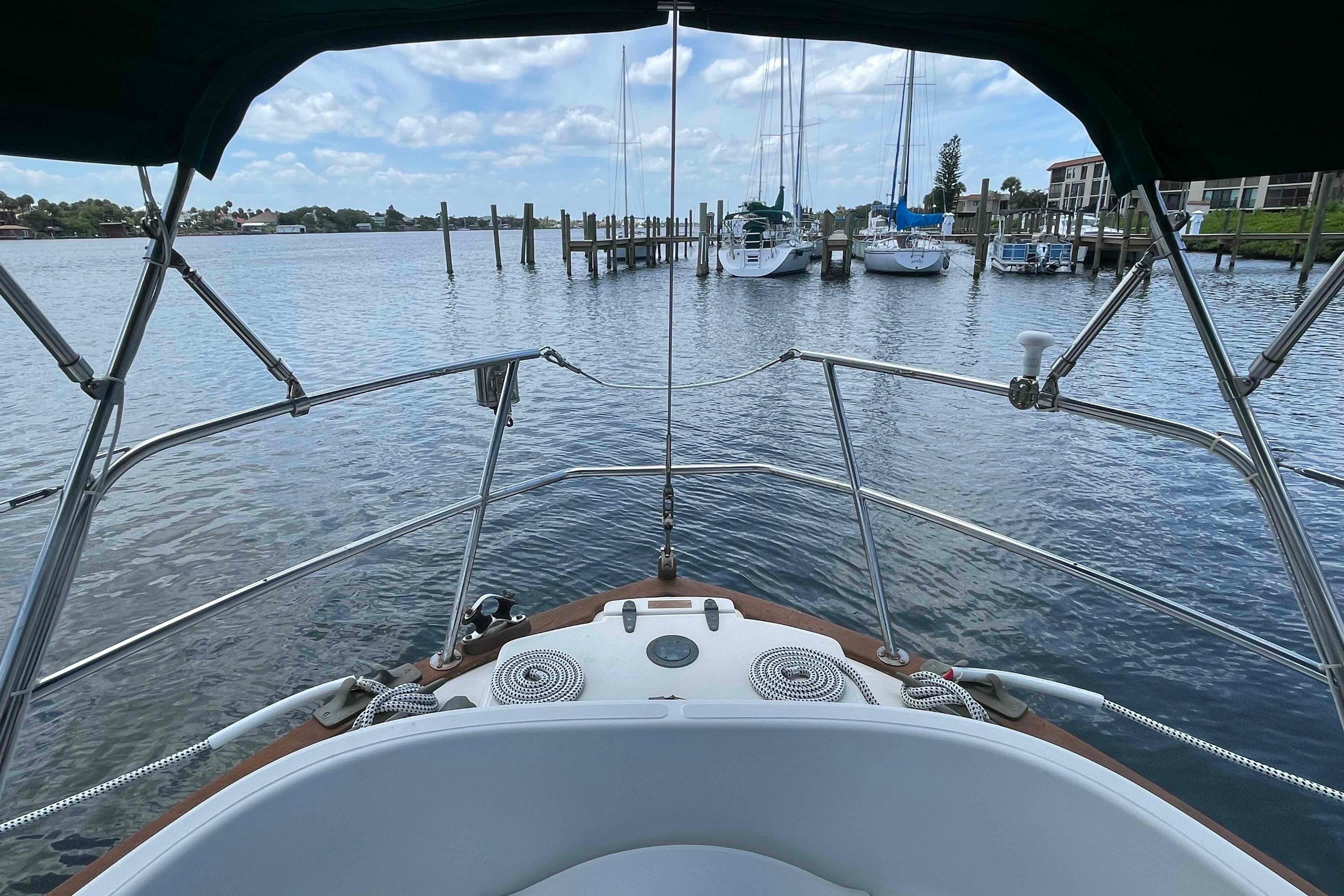 1987 Pacific Seacraft 34 sailboat docked in a marina with clear skies and calm waters.