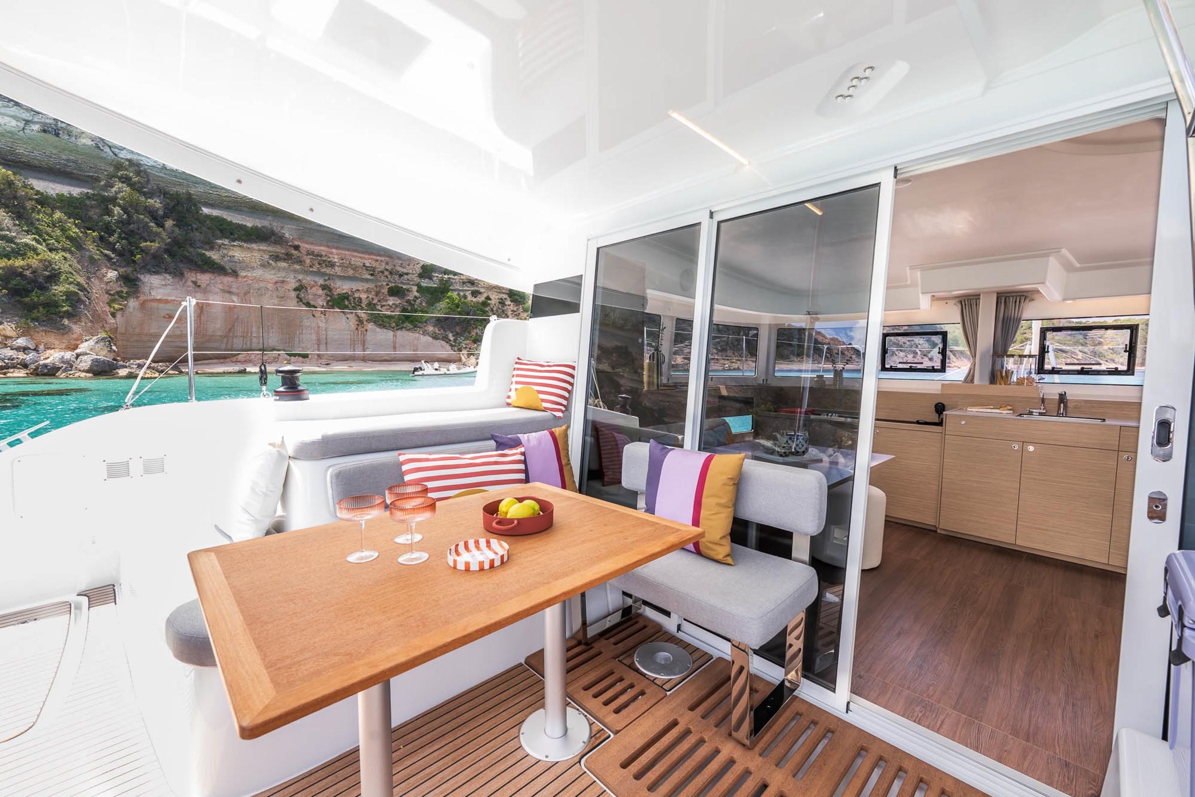 Luxurious Lagoon 38 catamaran interior with dining area, scenic ocean view, and modern amenities, 2025 model.