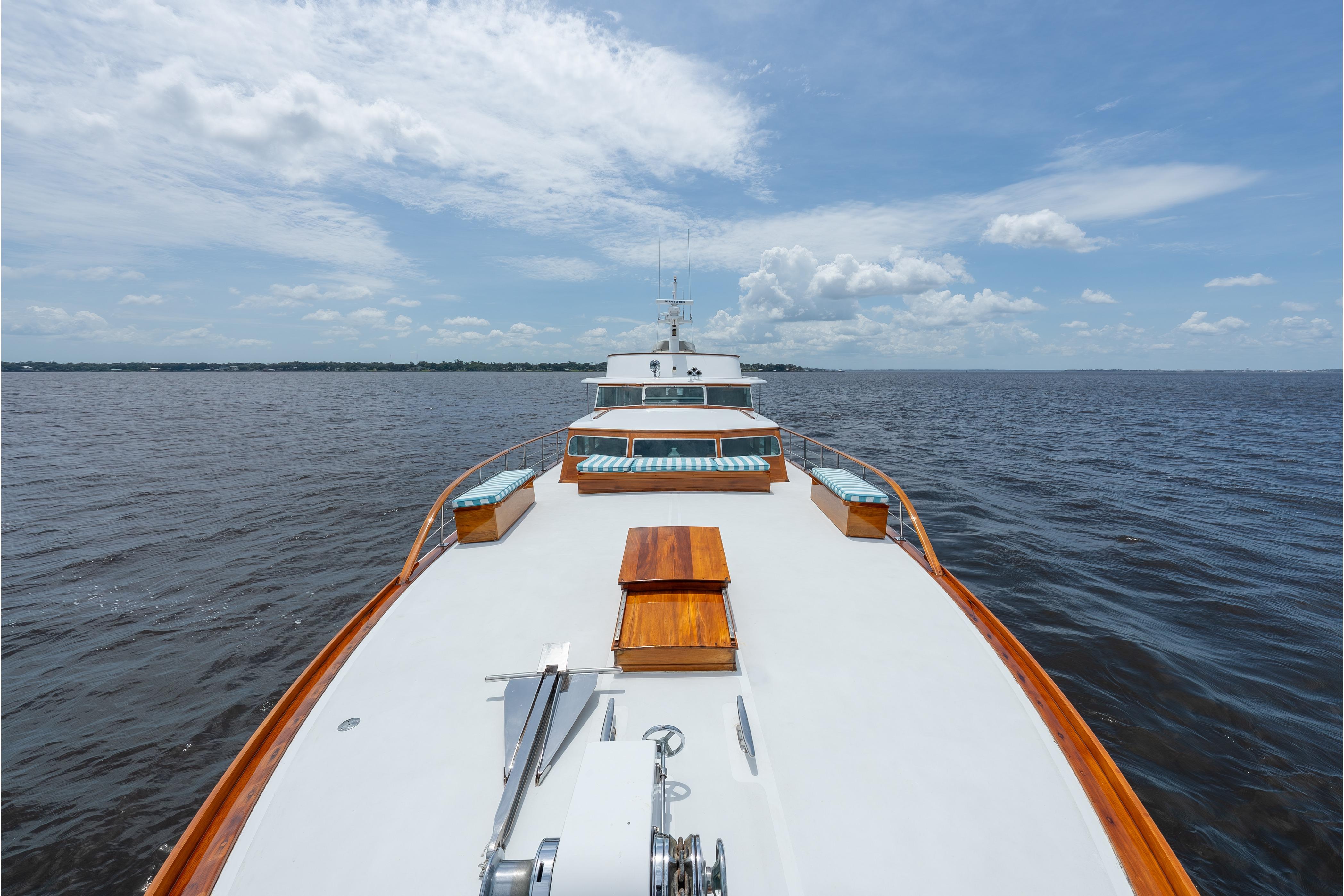 1963 Trumpy Classic yacht cruising on open water under a clear blue sky.