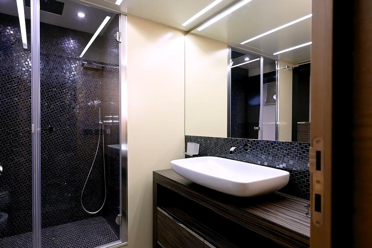 Luxurious bathroom on 2015 Pershing 92 yacht with modern sink and sleek shower design.