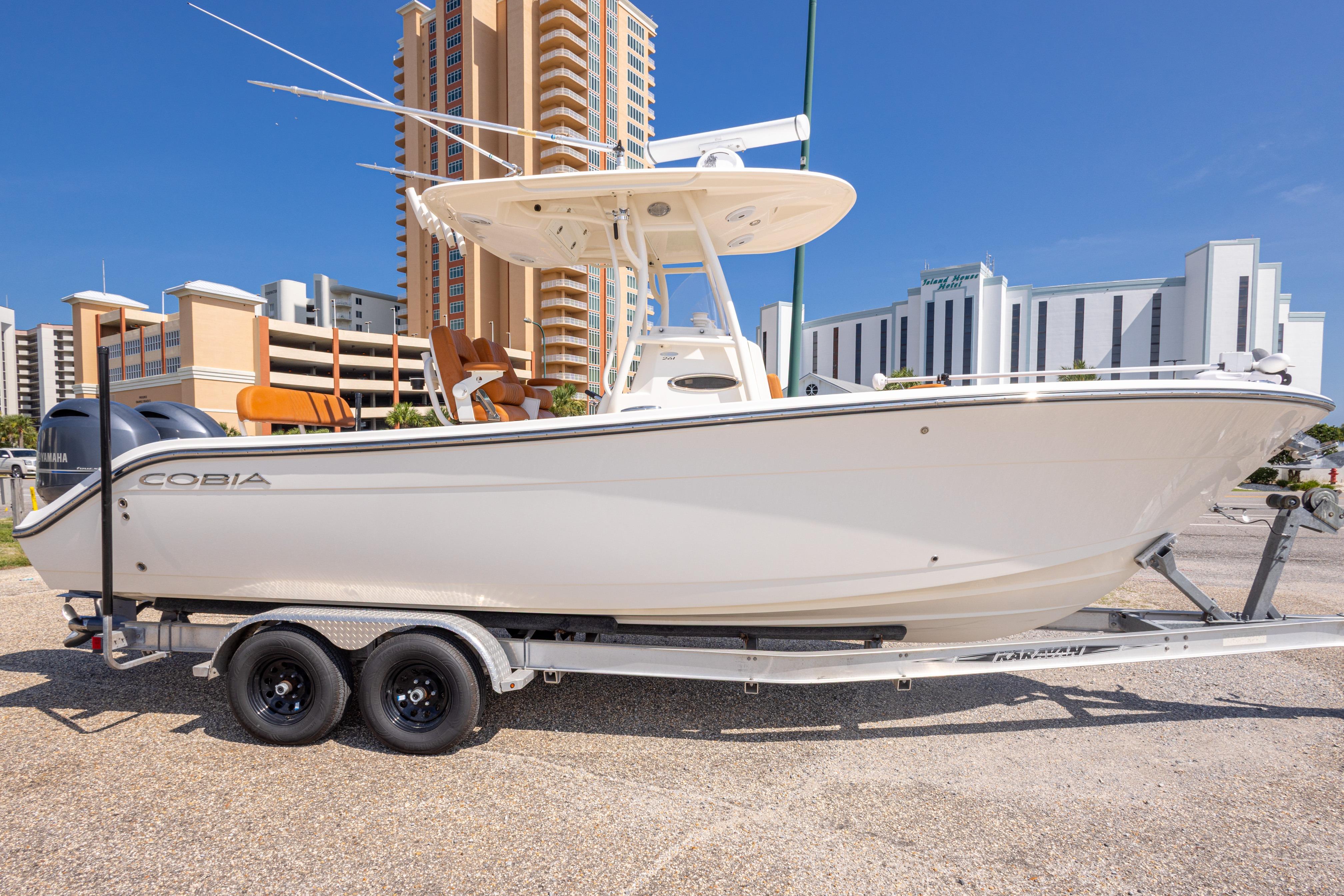 2017 Cobia 261 Center Console boat on trailer, urban backdrop.