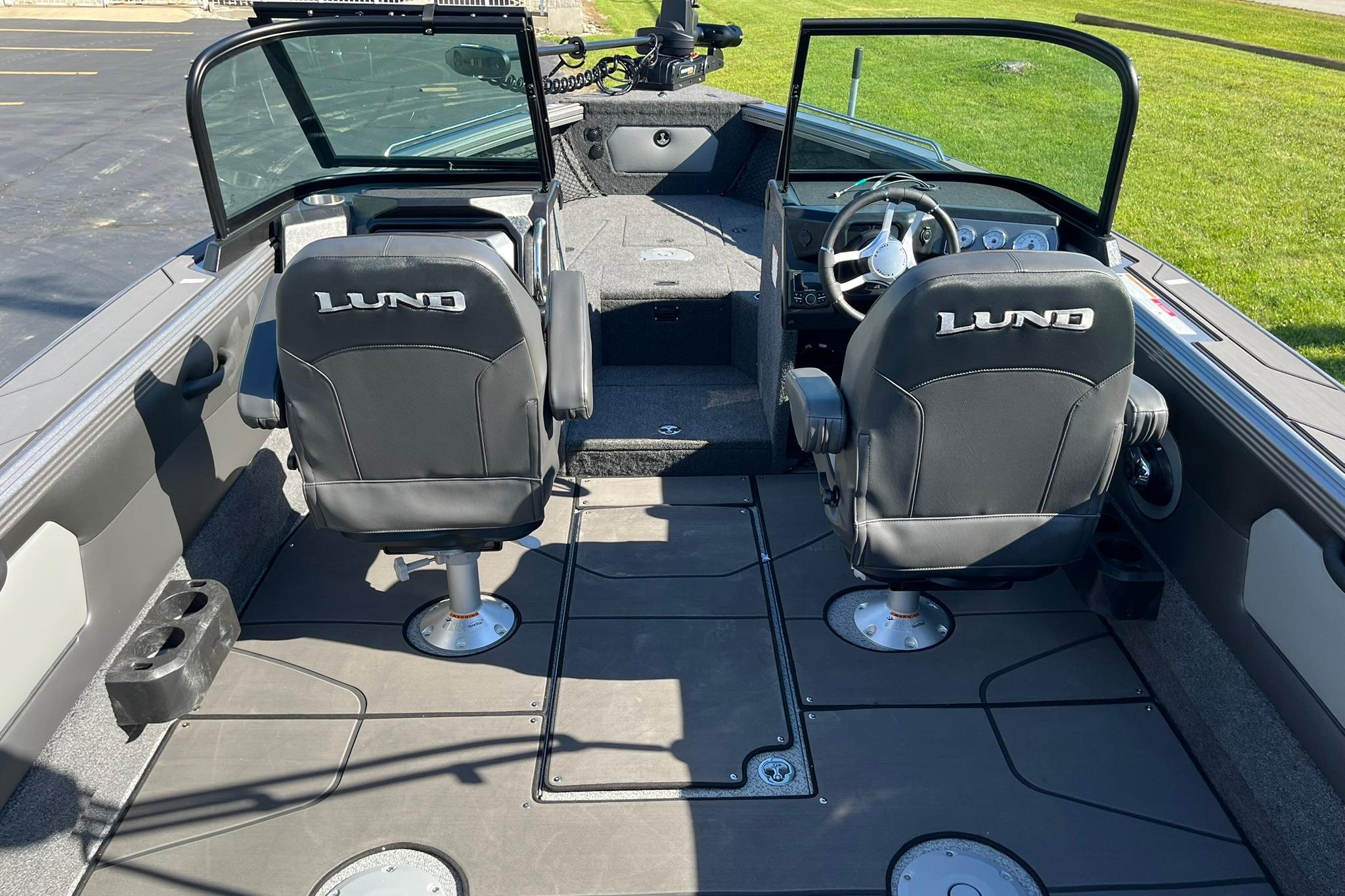 2026 Lund 2275 Baron boat interior with two black seats and steering console.