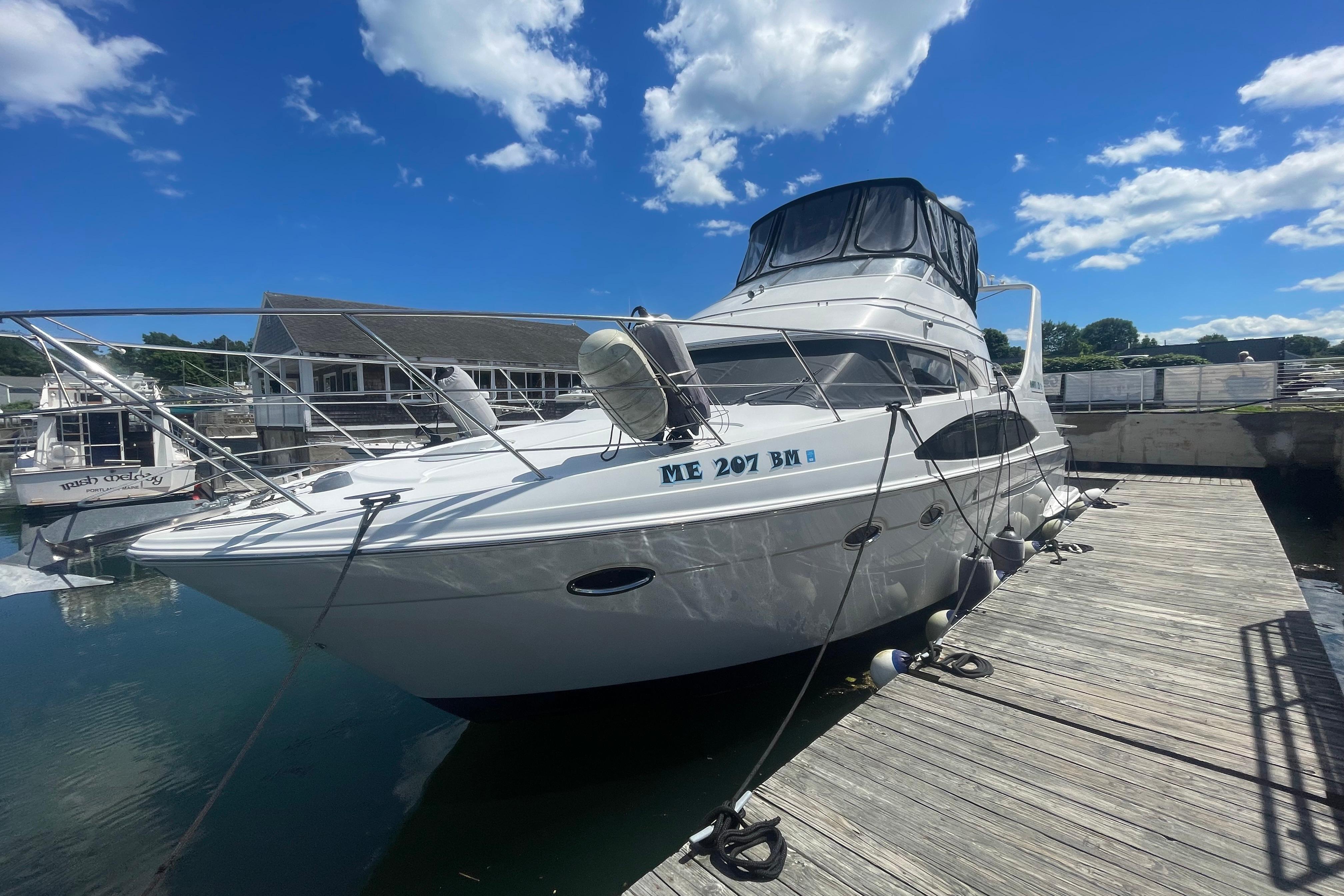 2002 Carver 410 Sport Sedan yacht docked under a clear blue sky.