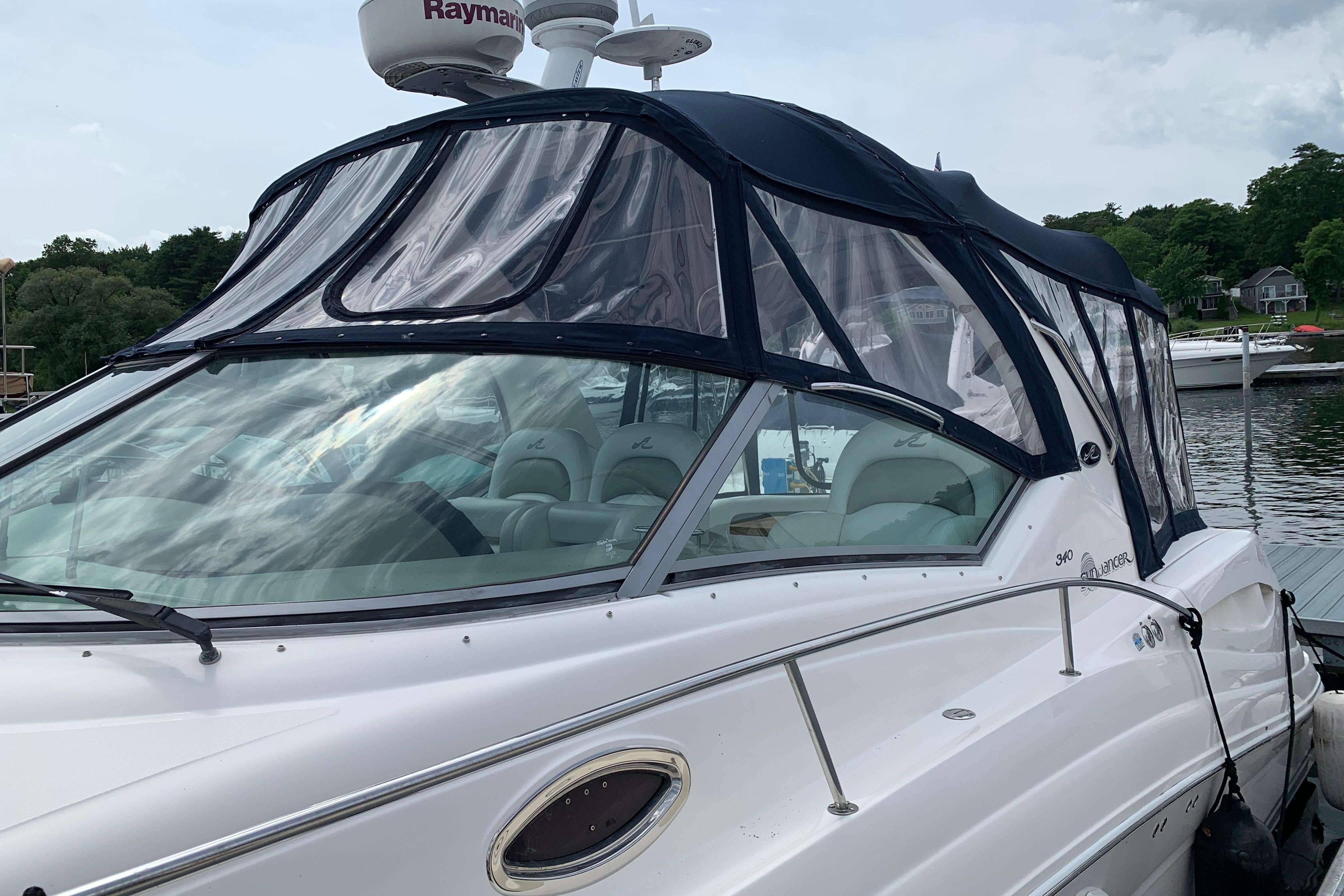 2007 Sea Ray 340 Sundancer boat docked with clear canopy and sleek design.