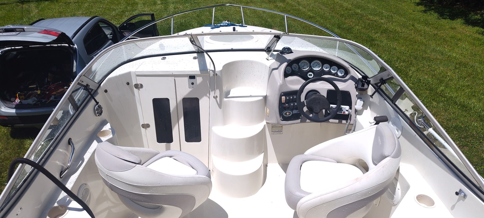 The image shows the cockpit of a 2002 Stingray 240 CR boat with two seats and a helm.