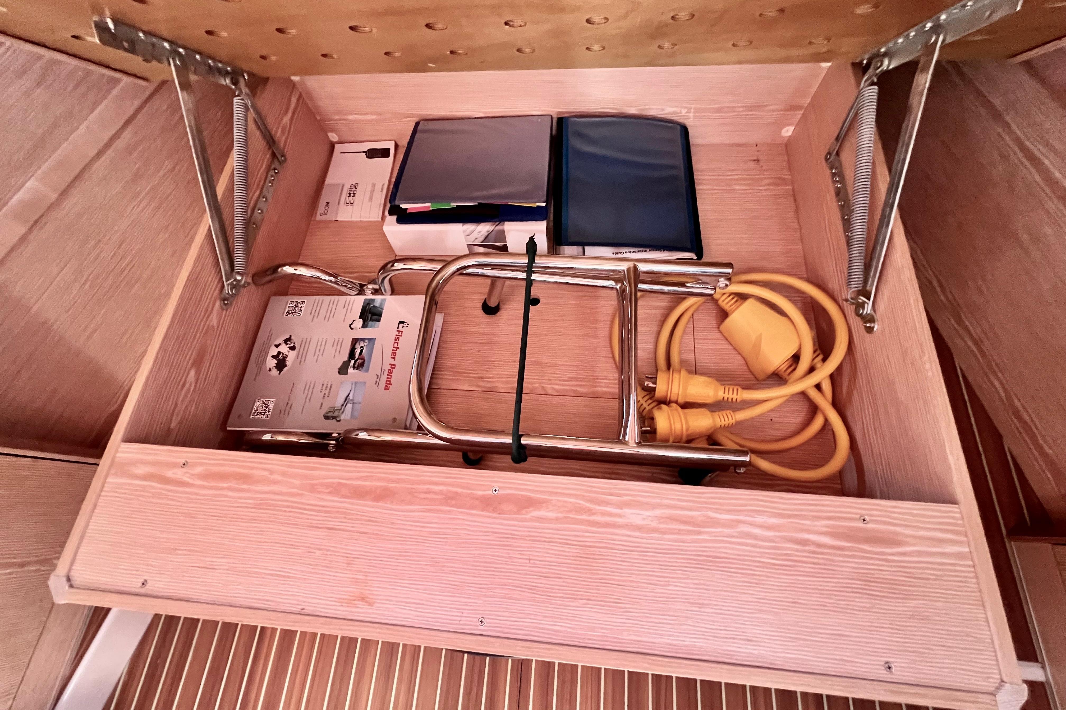 Storage compartment in a 2016 Hanse 455 yacht with cables and manuals.