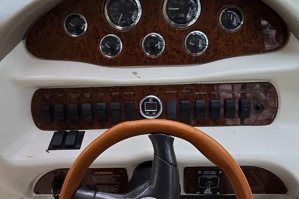 1999 Sea Ray 280 SS dashboard with wood accents and steering wheel.