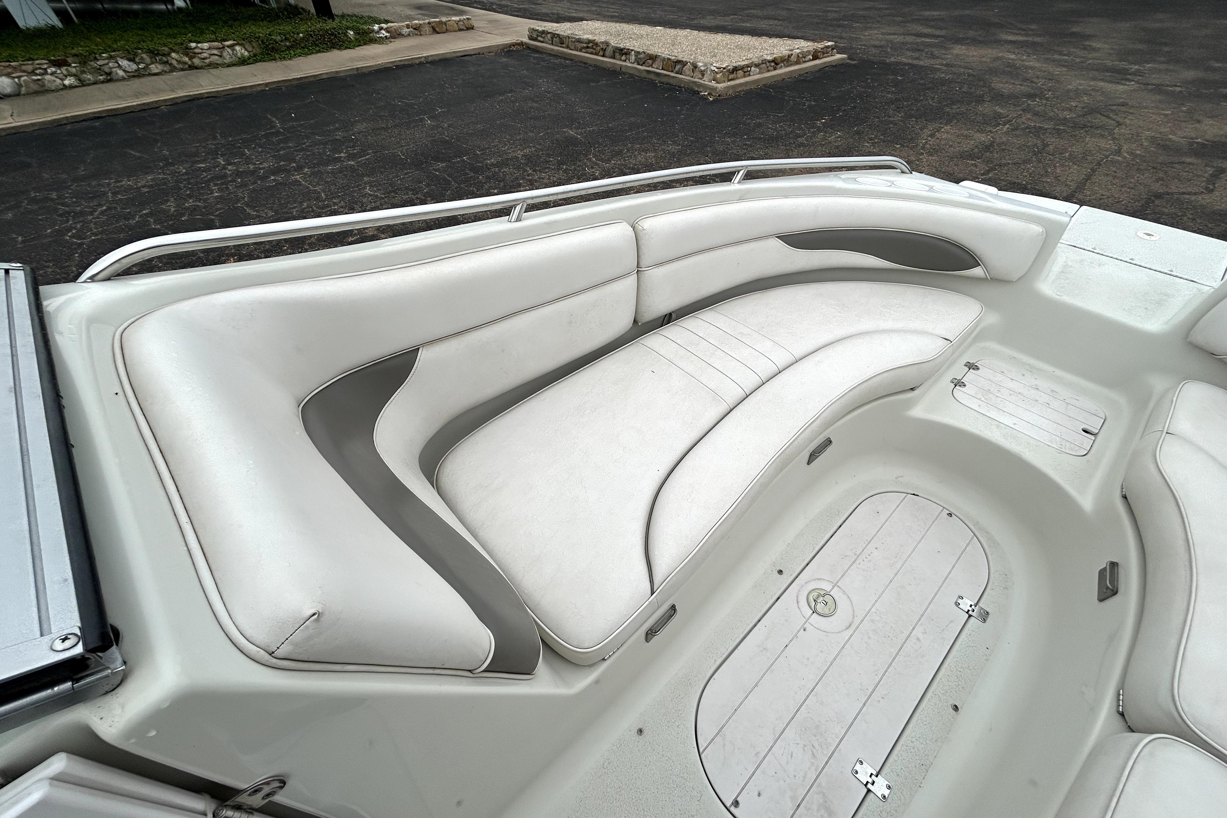 2001 Crownline 239 DB boat interior with white cushioned seating and storage compartments.
