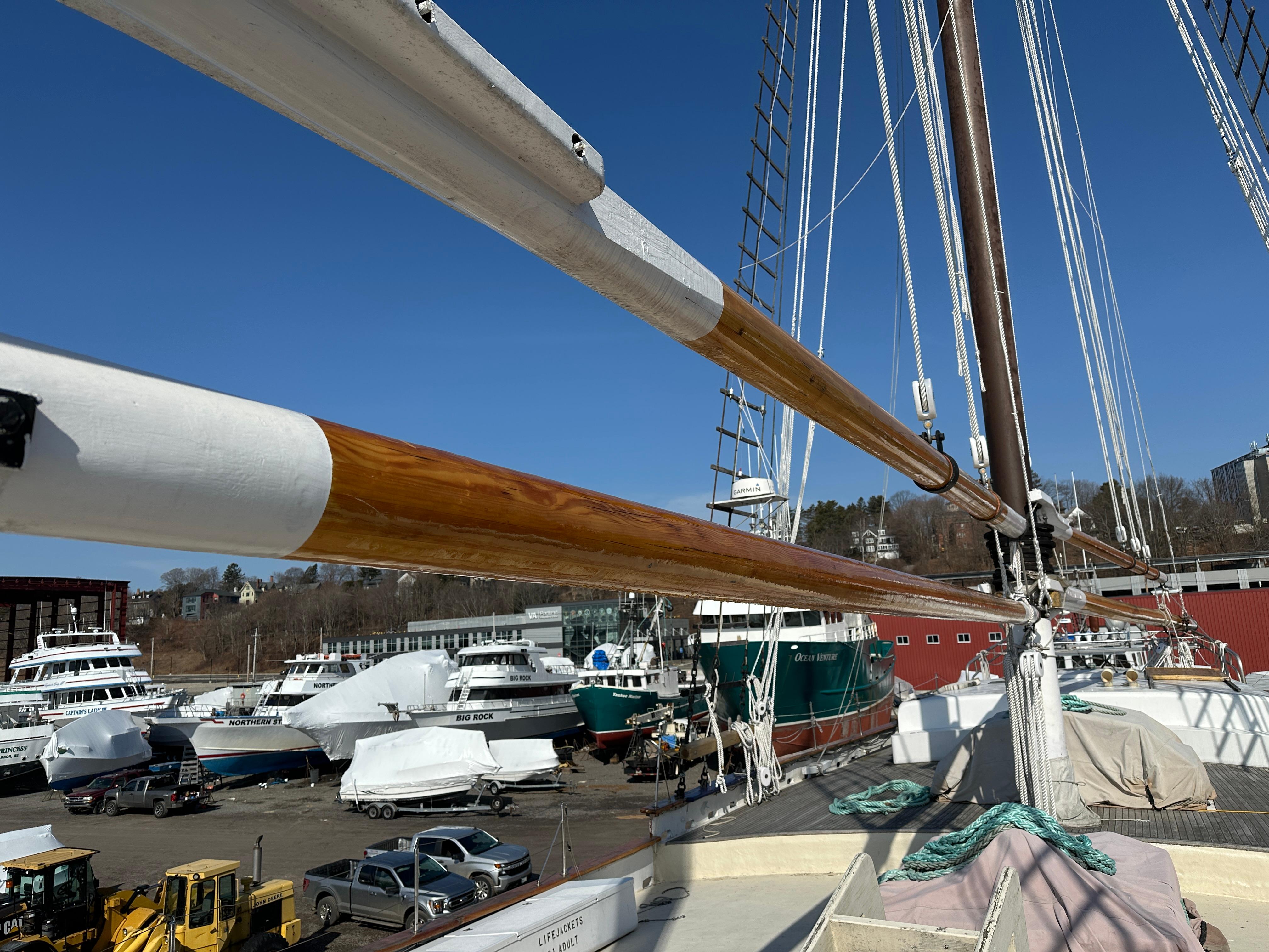 Schooner HARRIS and BISHOP 2006 in a shipyard with other boats, clear blue sky.