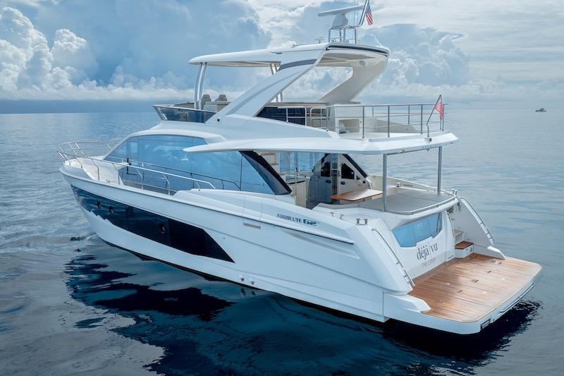 2023 Absolute 62 Fly yacht on calm ocean waters under cloudy sky.