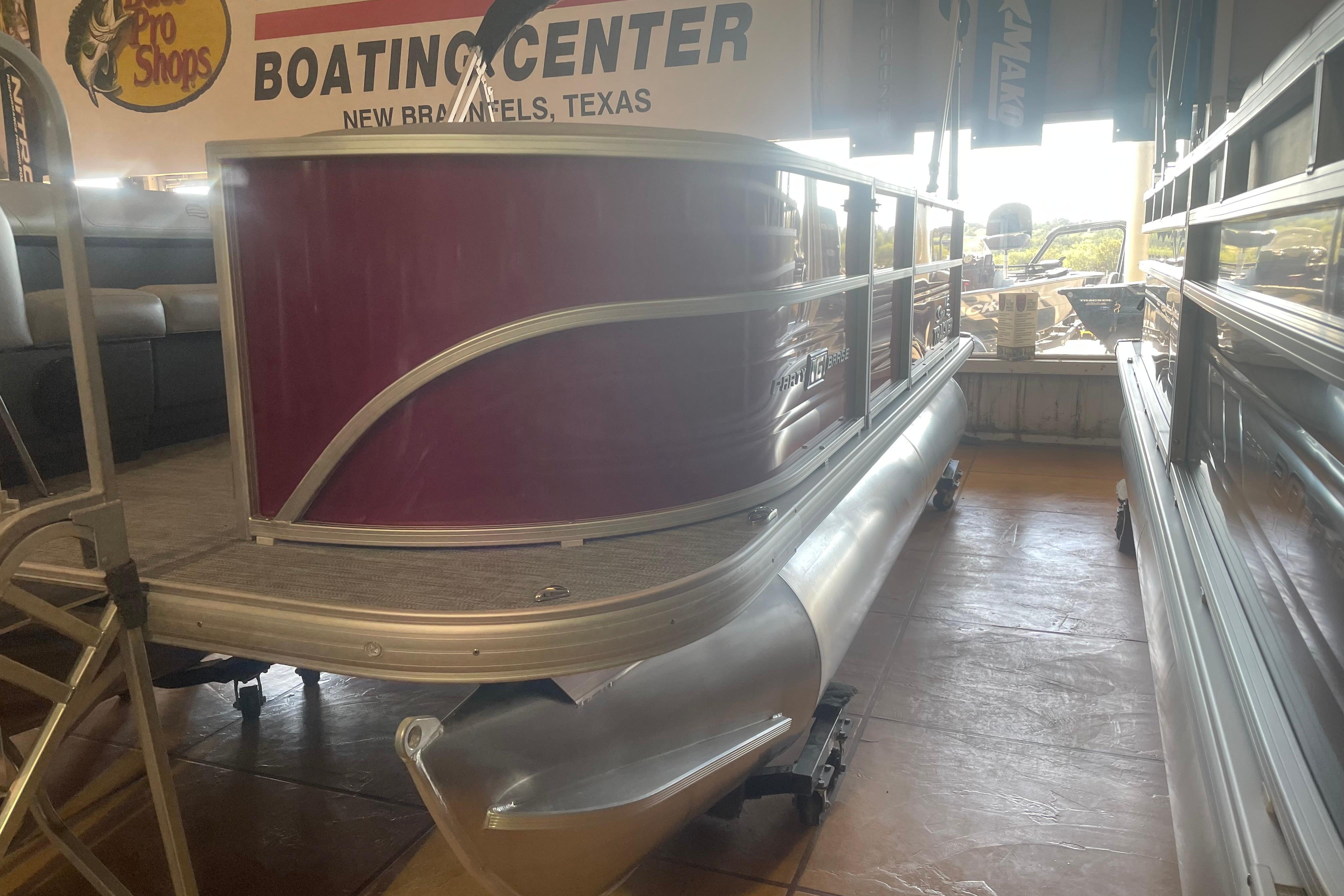 2026 Sun Tracker Party Barge 16 DLX pontoon boat displayed at a boating center.