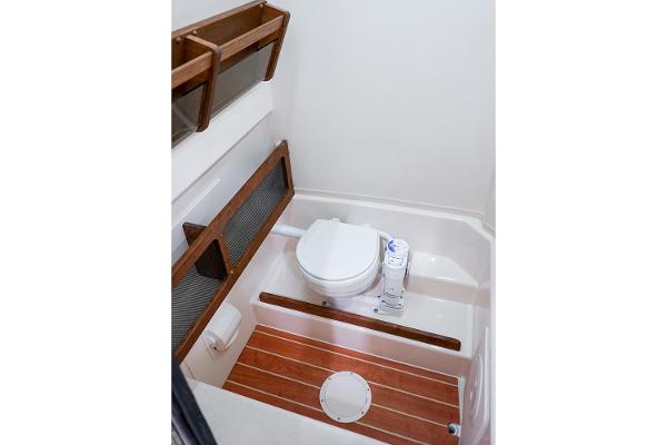 Manufacturer Provided Image: 2024 Grady-White Canyon 271 boat bathroom with wooden accents and modern toilet.