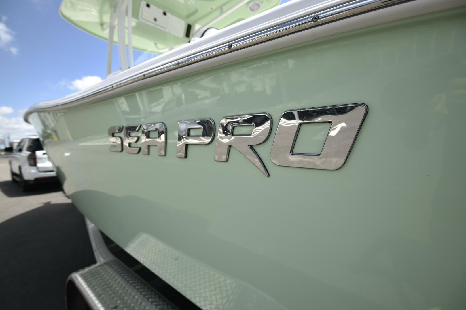 2023 Sea Pro 239 Deep V CC boat with chrome logo, side view.
