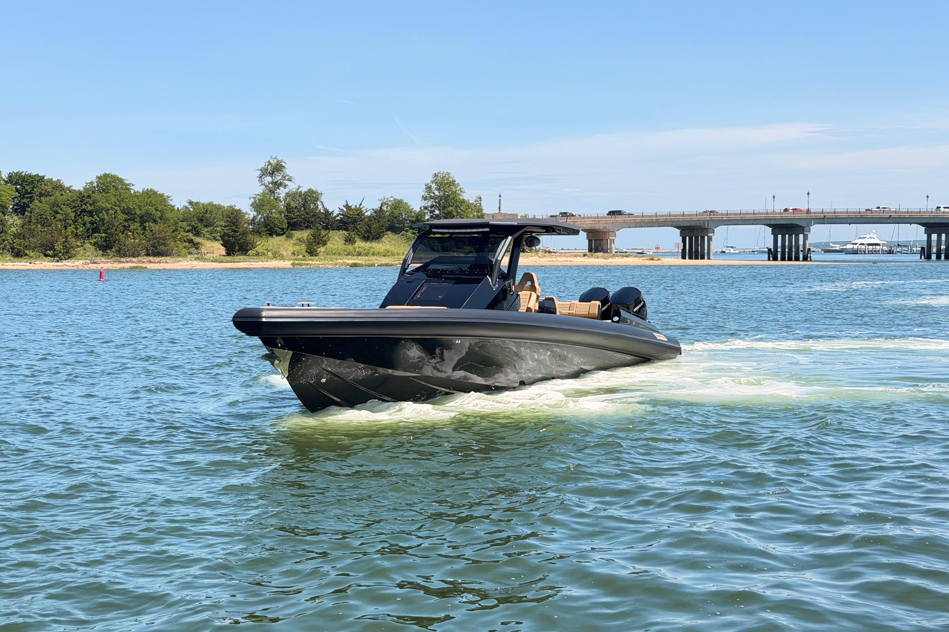2023 Skipper-BSK 42NC boat cruising on a sunny day near a bridge.