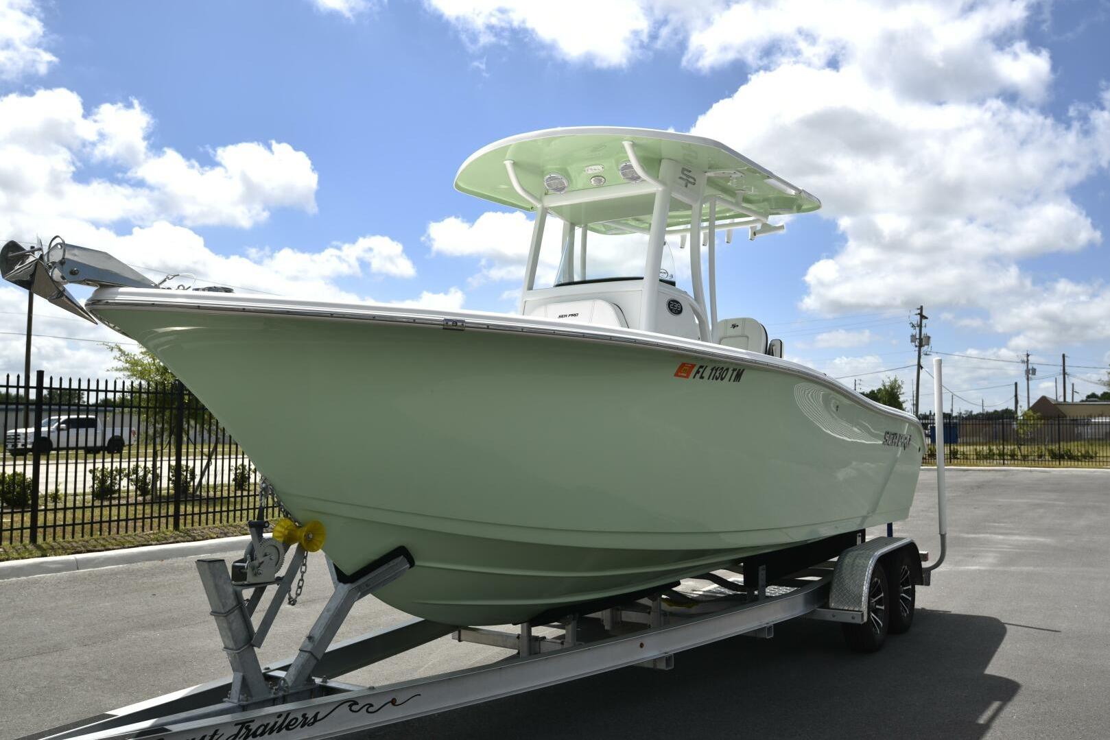 2023 Sea Pro 239 Deep V CC boat on trailer under blue sky.