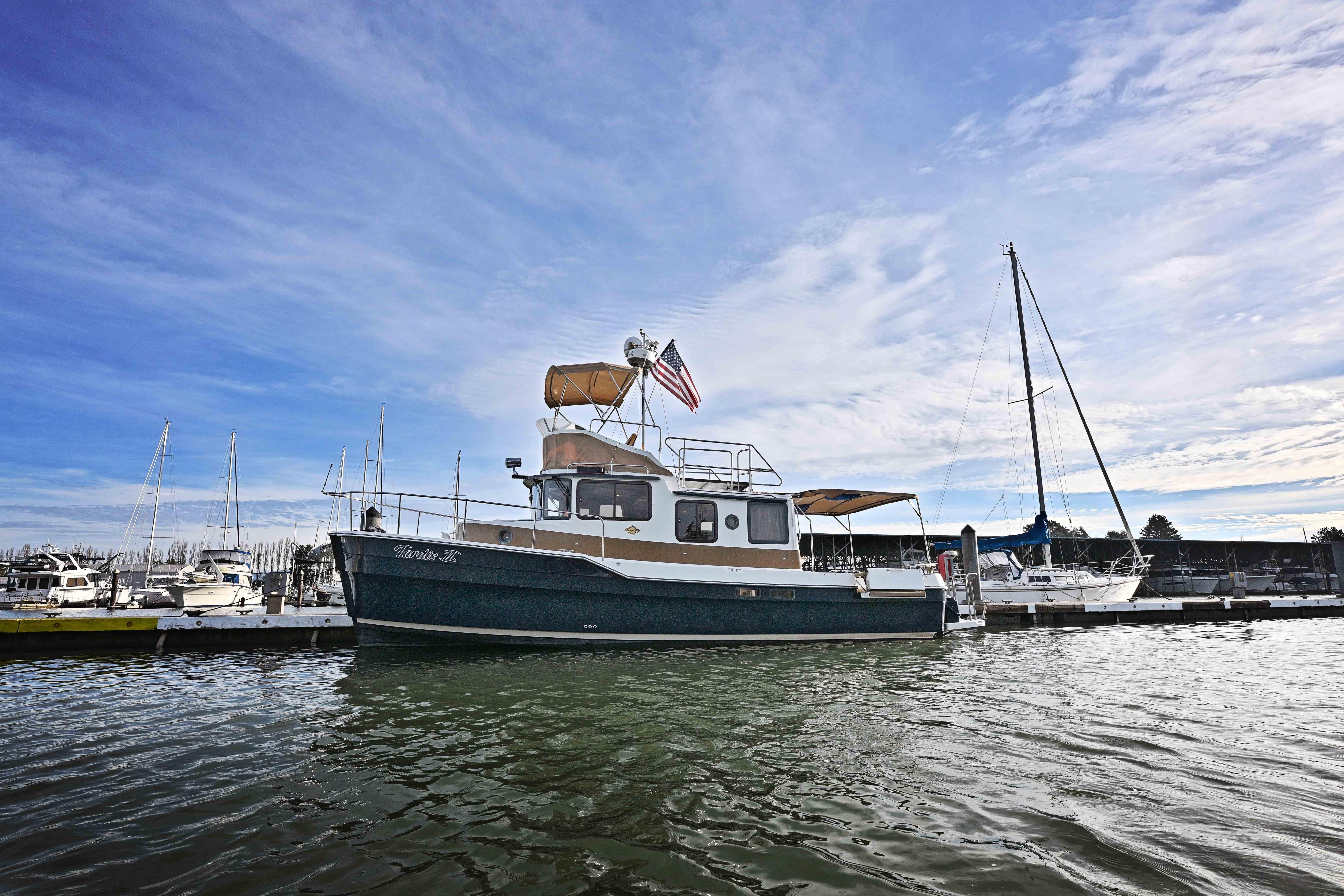 2014 Ranger Tug R-31 CB docked at marina under blue sky.
