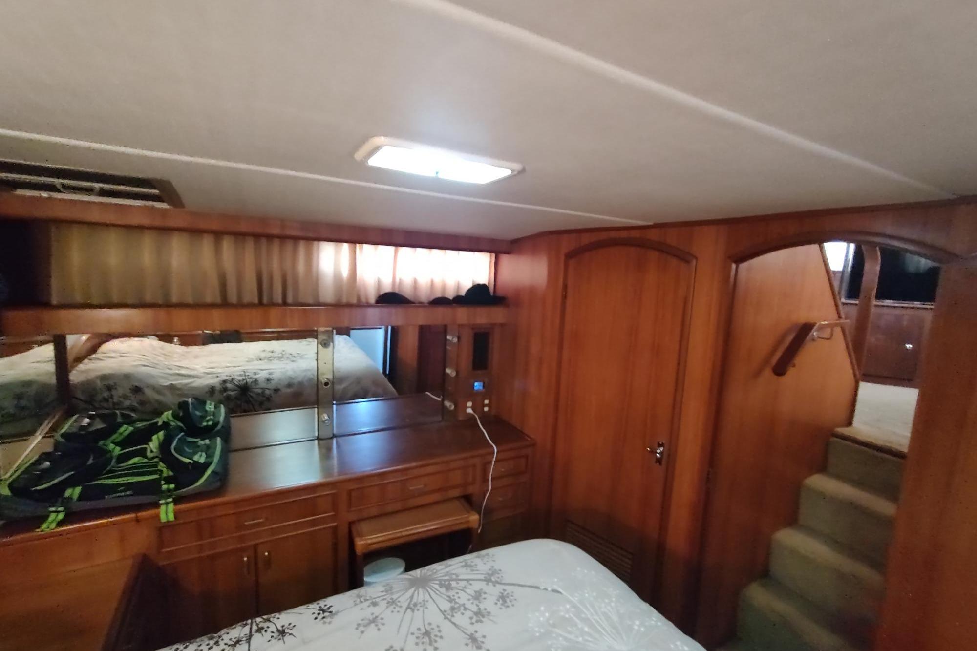 1989 Hyatt Double Cabin Motoryacht interior with wooden cabinetry and cozy sleeping area.