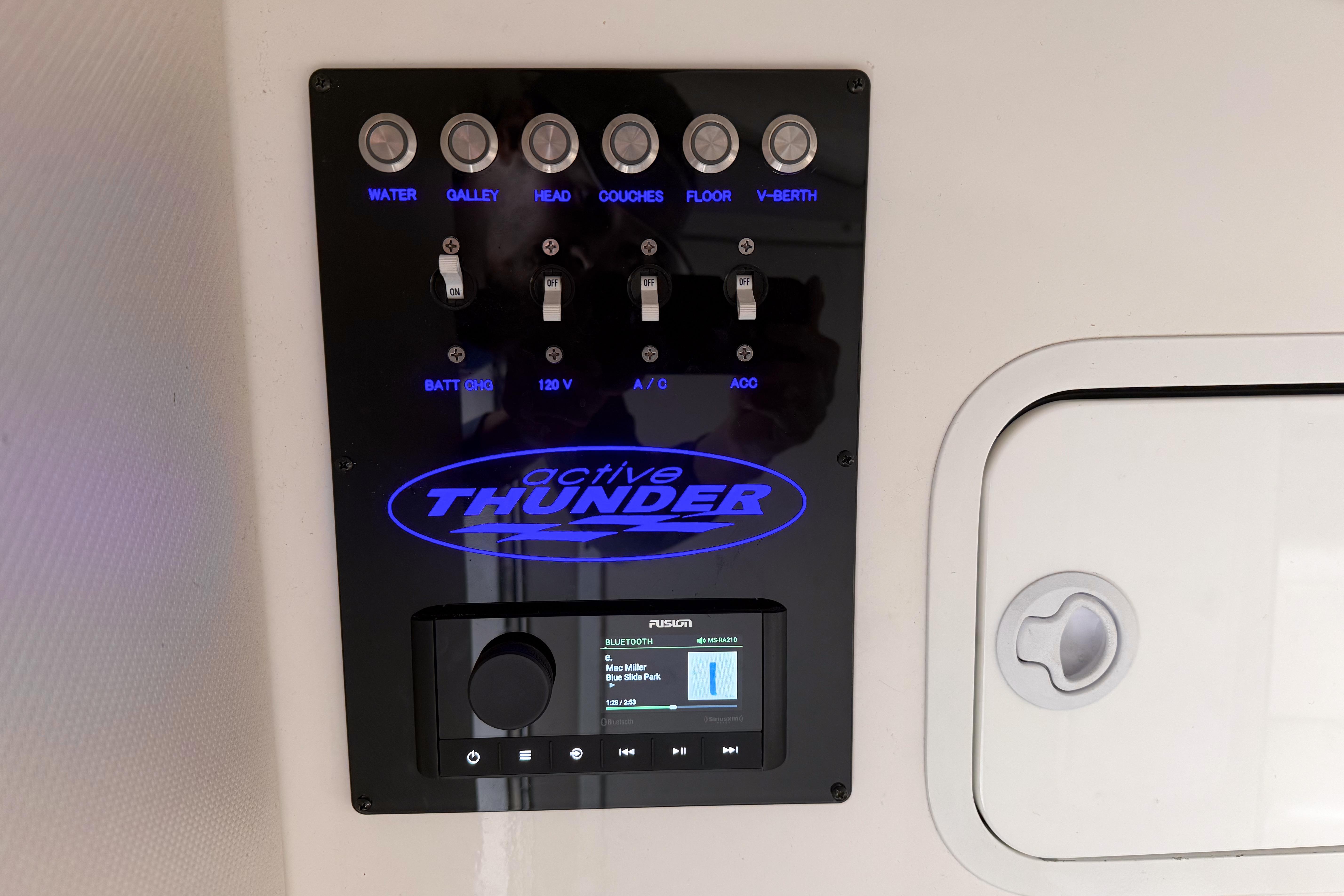 Control panel of a 2002 Active Thunder 37 boat with labeled switches and audio system.