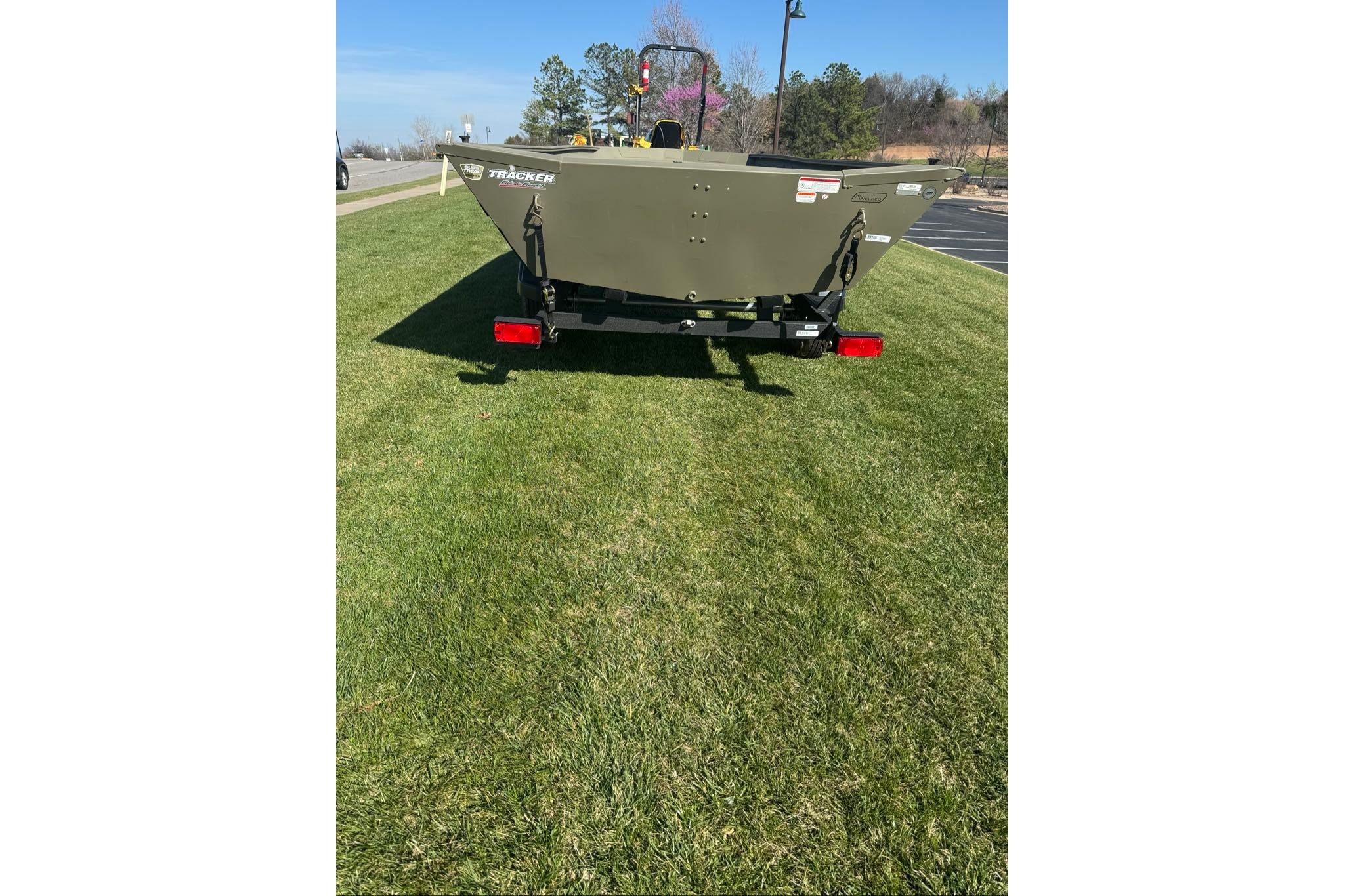2026 Tracker Grizzly 1754 Utility boat on grass, rear view, sunny day.