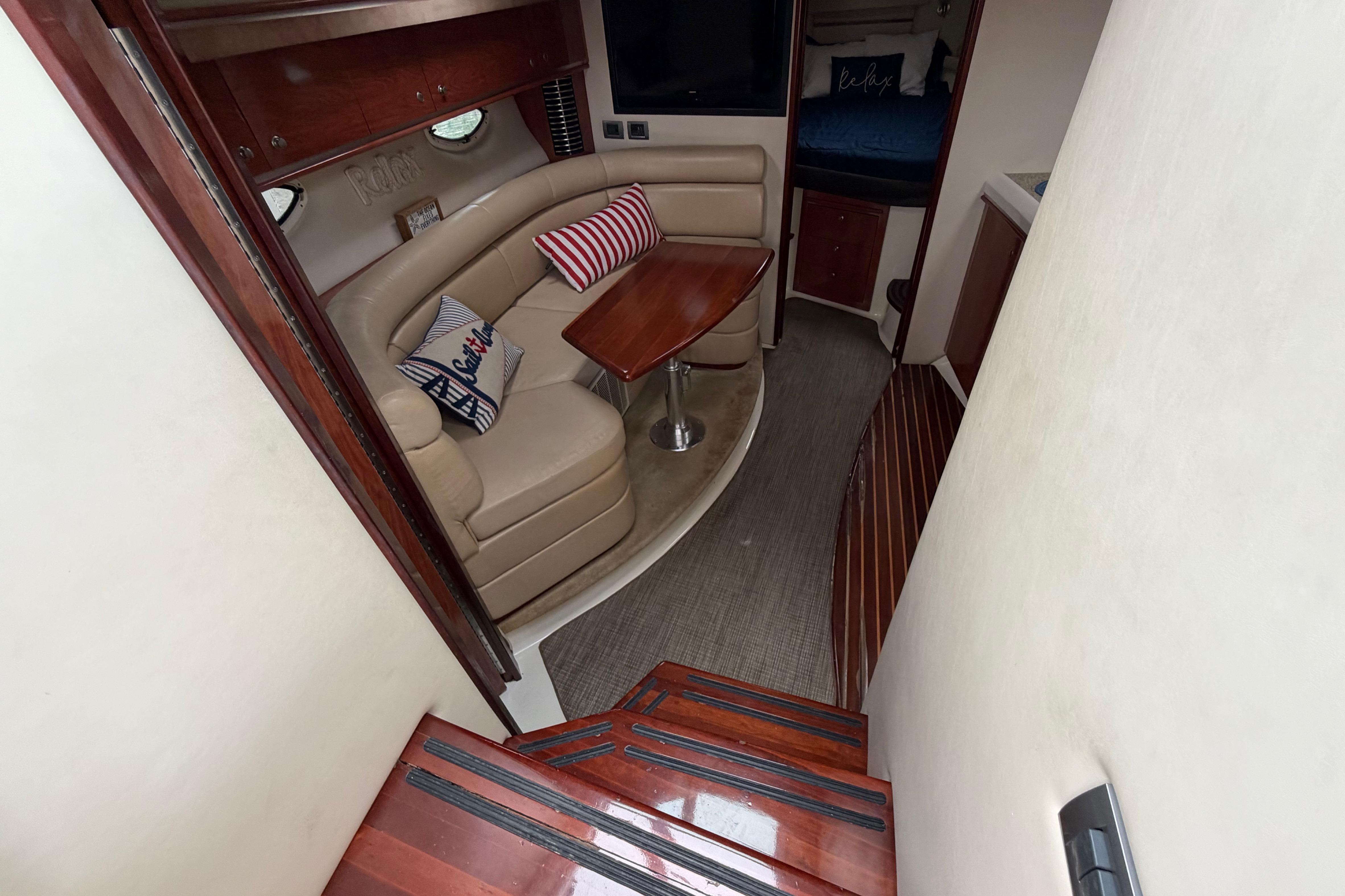 Interior of 2007 Monterey 350 Sport Yacht with cozy seating and wooden accents.
