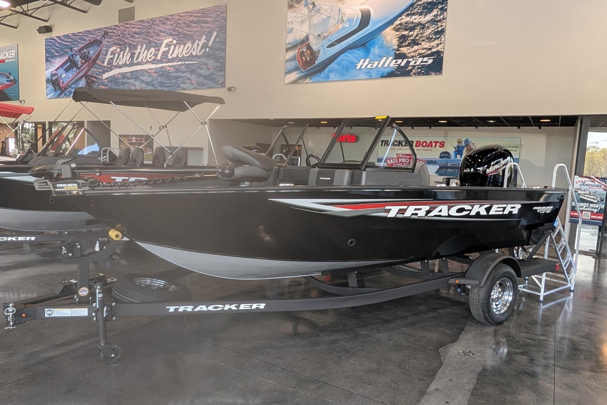 2026 Tracker Pro Guide V-175 Combo boat displayed in showroom with promotional banners.
