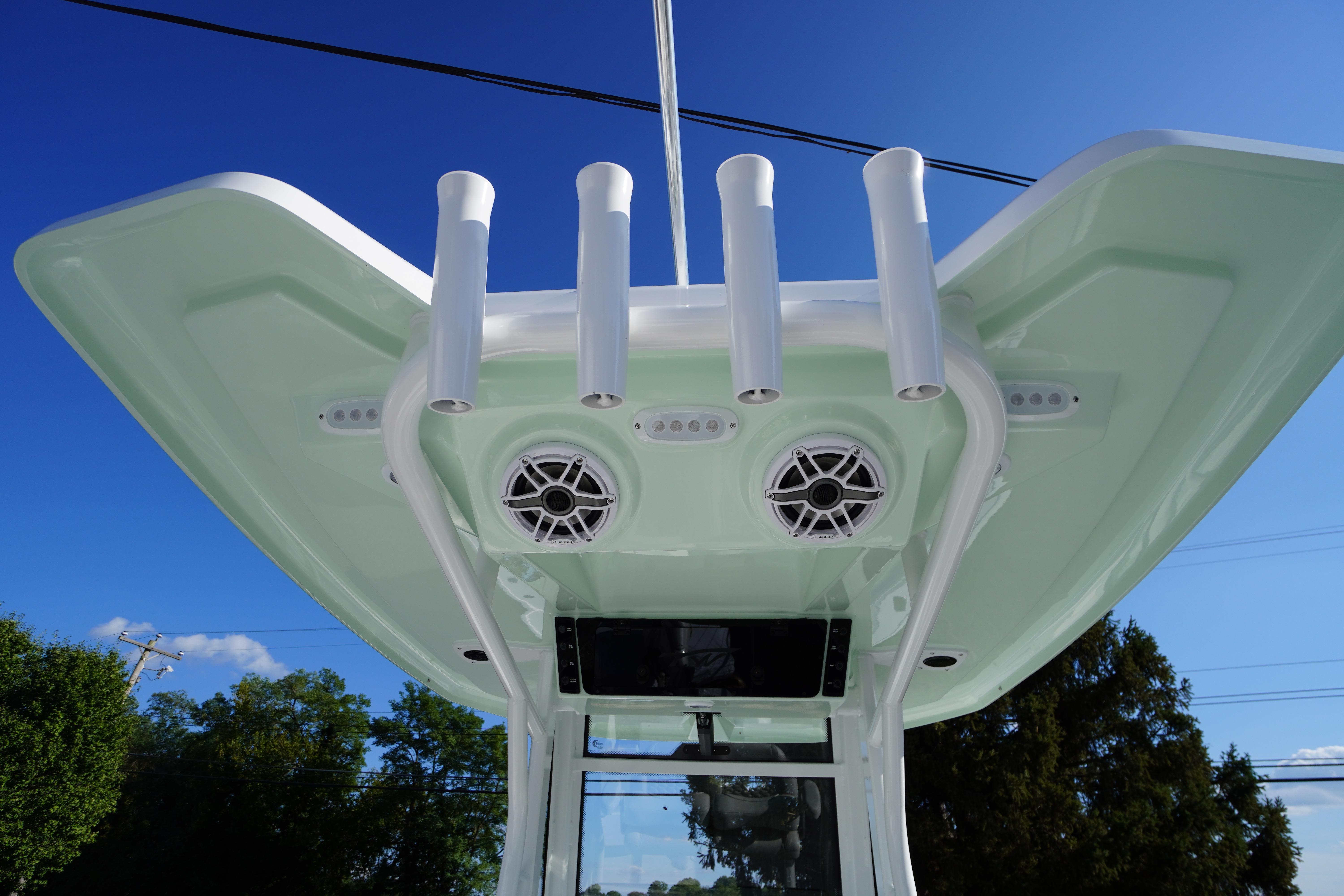 2026 Tidewater 272 LXF boat with rod holders and speakers under a clear blue sky.