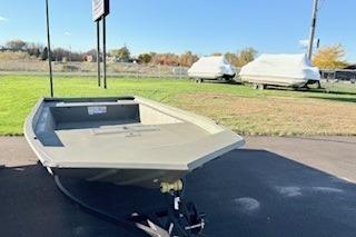 2026 Tracker Grizzly 1860 Utility boat on trailer, parked outdoors on sunny day.