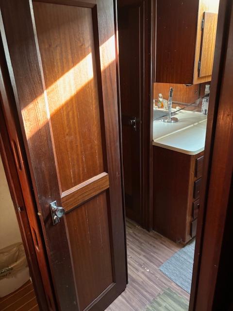 1976 Hatteras 46 interior with wooden door, kitchenette, and natural light.