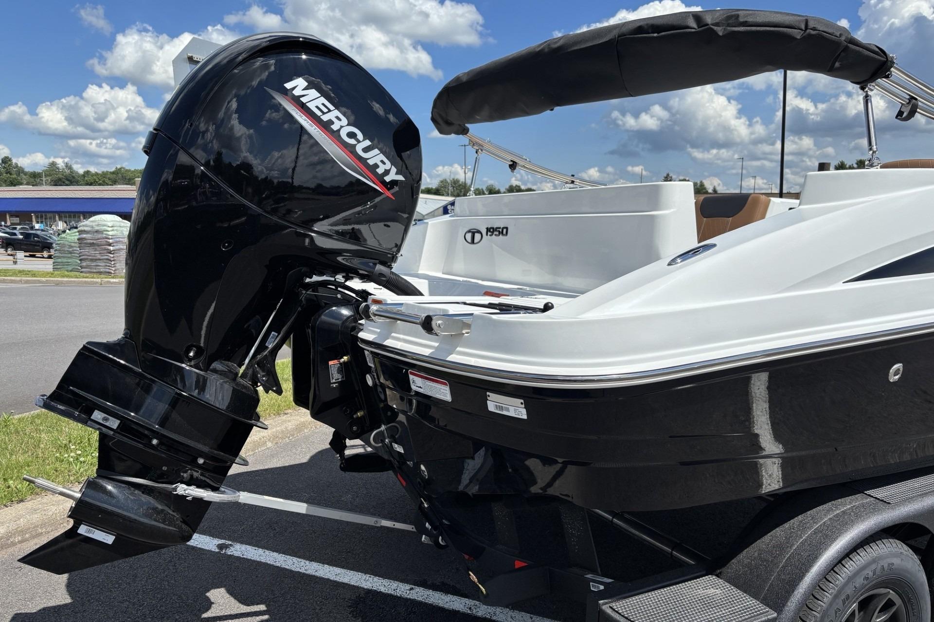 2026 Tahoe 1950 boat with Mercury outboard motor, parked outdoors under a blue sky.